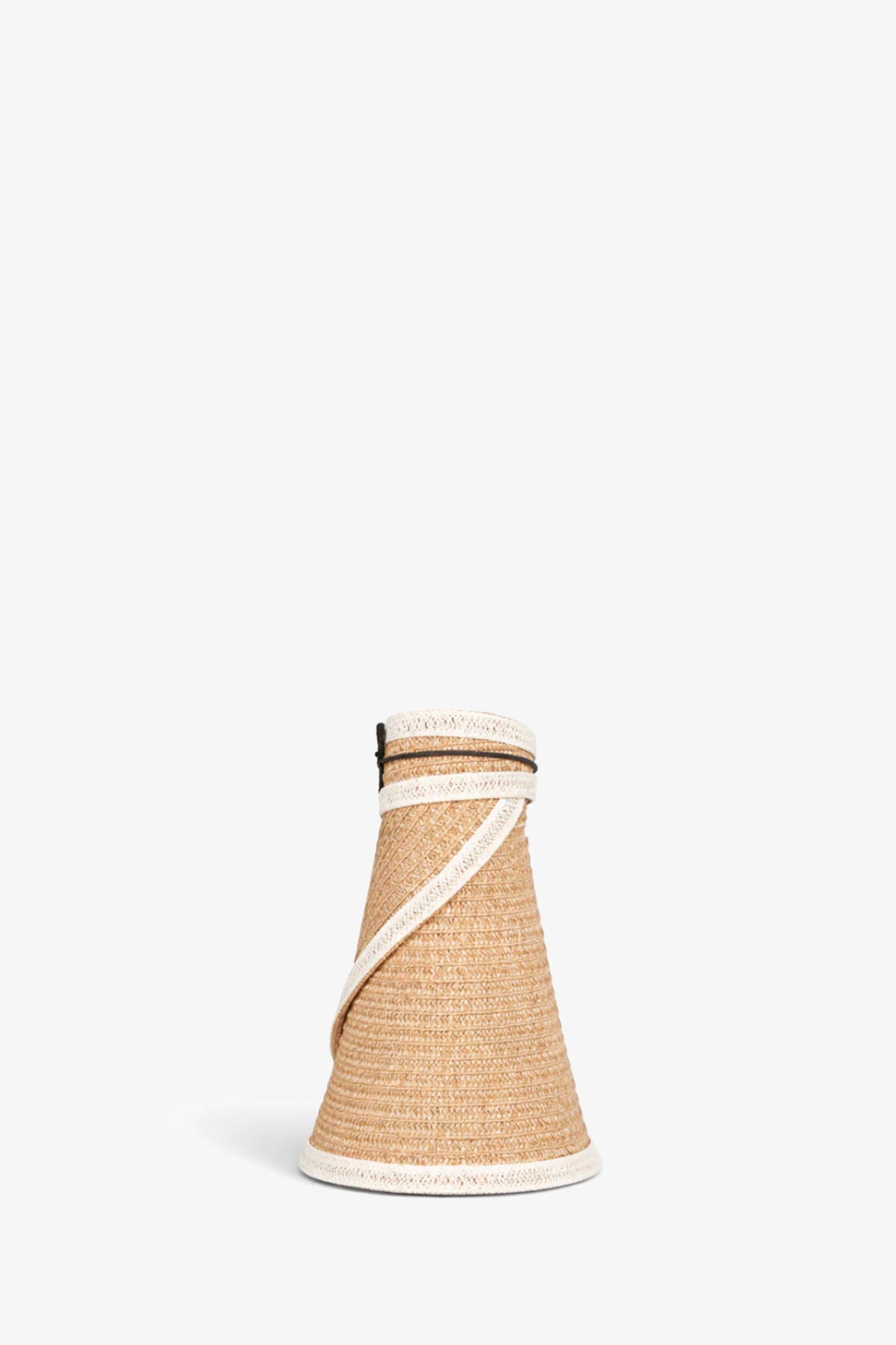 The Trixie Visor is a woven, cone-shaped straw bag featuring white trim and a slim tan shoulder strap, shown on a plain white background.