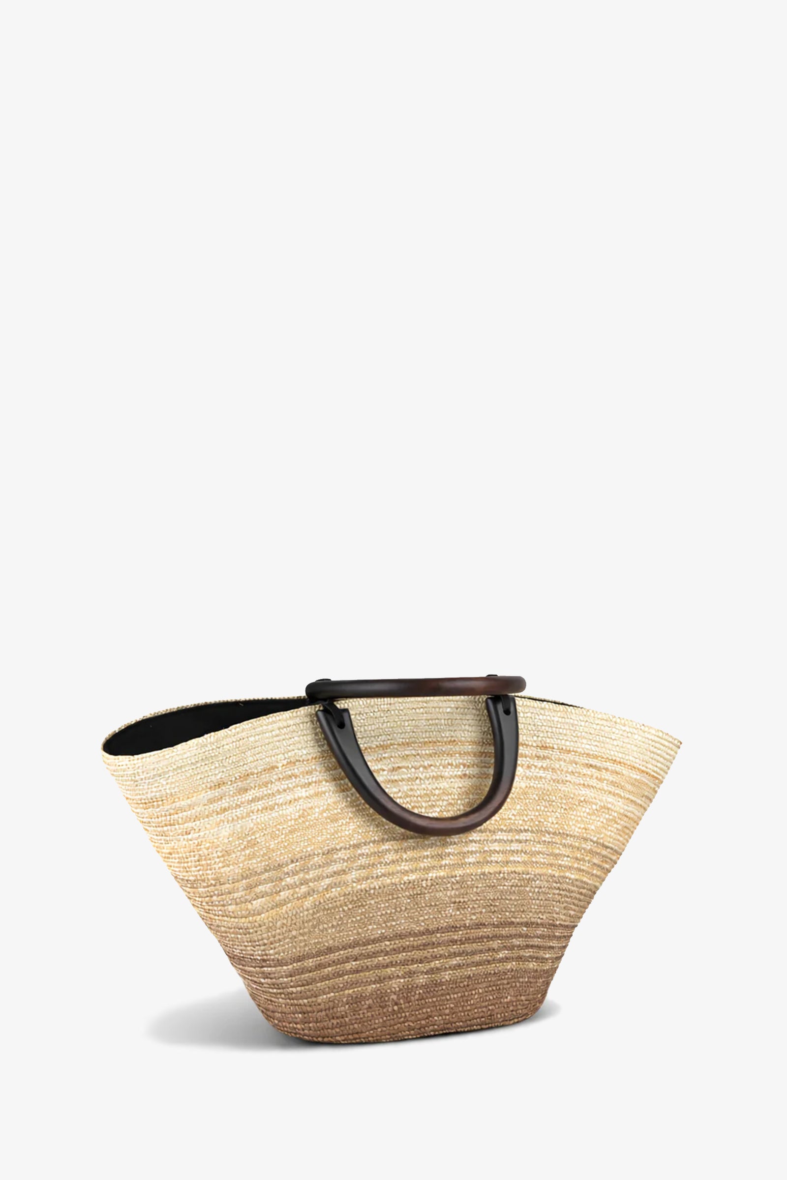 The Carlotta Ombre Tote is a spacious woven straw bag with a light beige-to-brown gradient and dark brown curved handles, shown against a plain white background.