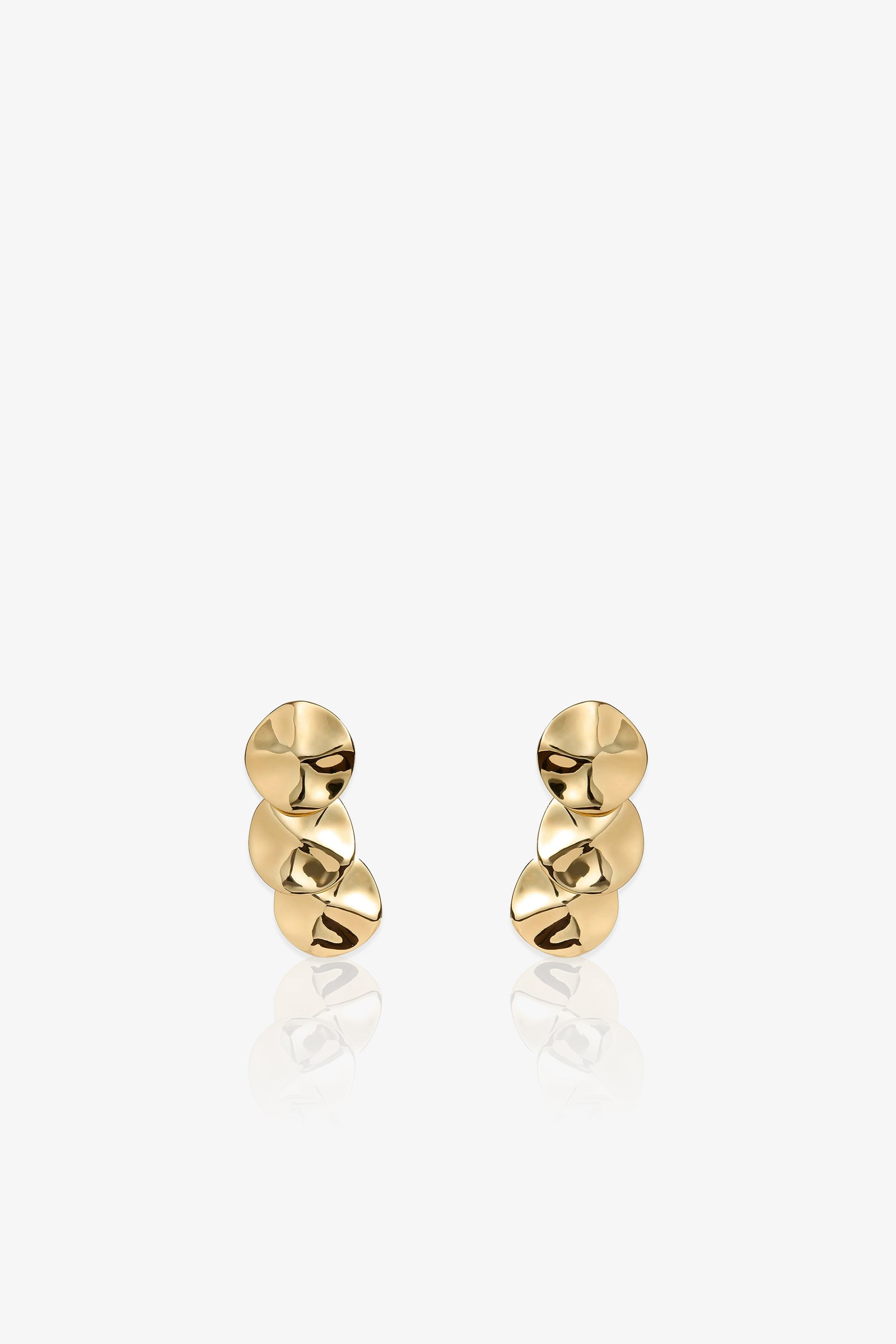 A pair of Socialite Statement Earrings, each featuring three irregular, disc-shaped gold pieces stacked vertically, displayed against a plain white background.