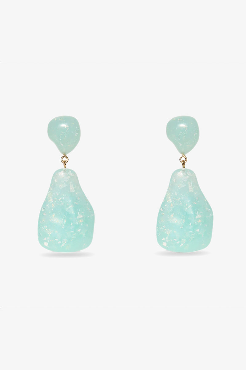 The Wilma Earrings in Ocean feature glossy, irregularly shaped aqua blue stones with a smaller matching stone above, creating a unique drop design.