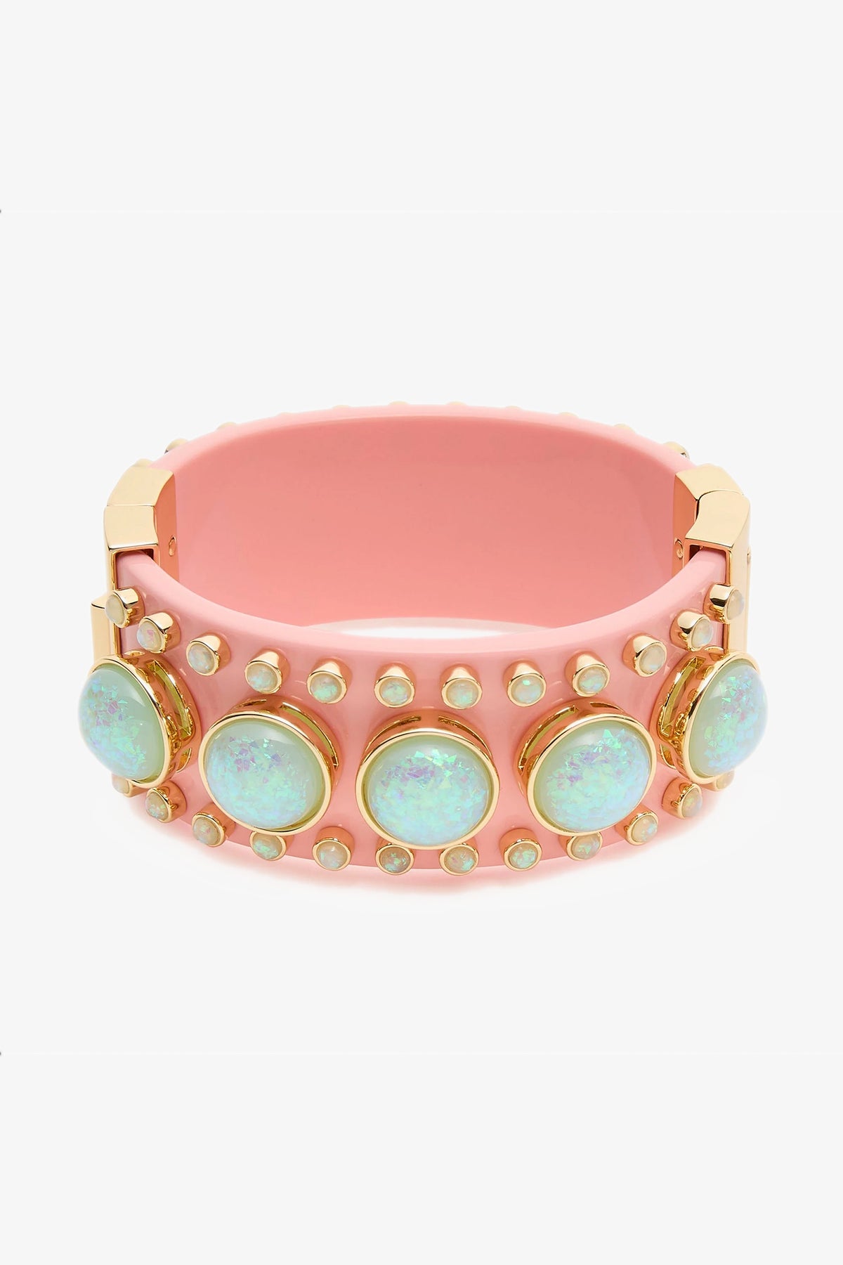 The Deco Hinged Cuff is a wide pink bracelet with gold accents, adorned with large iridescent opal-like stones and rows of small round studs around its surface.