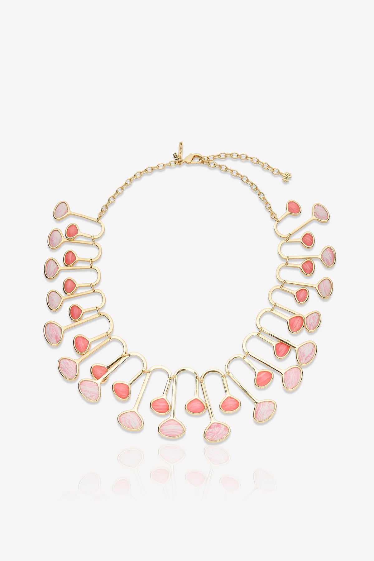 The Flamingo Necklace is a gold necklace with a chain clasp, featuring 22 pink and coral oval stones set in a fan-like pattern. The stones are arranged in pairs along curved gold frameworks, creating a bold, elegant statement piece.