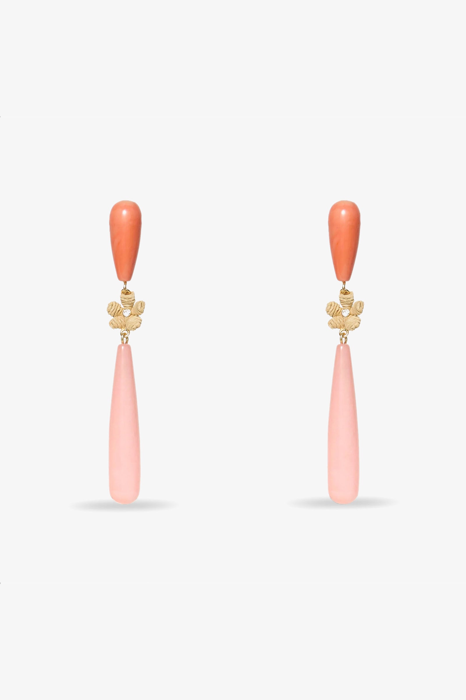The Flamingo Linear Earring in coral features pink teardrop stones, gold floral accents, and rounded coral tops, shown on a white background.