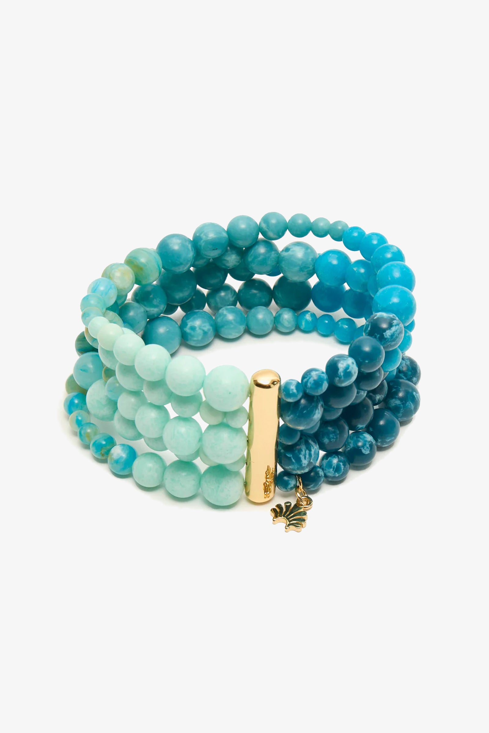 The Riviera Five Strand Bracelet features blue and turquoise round beads, a gold cylindrical clasp, and a small gold leaf charm.