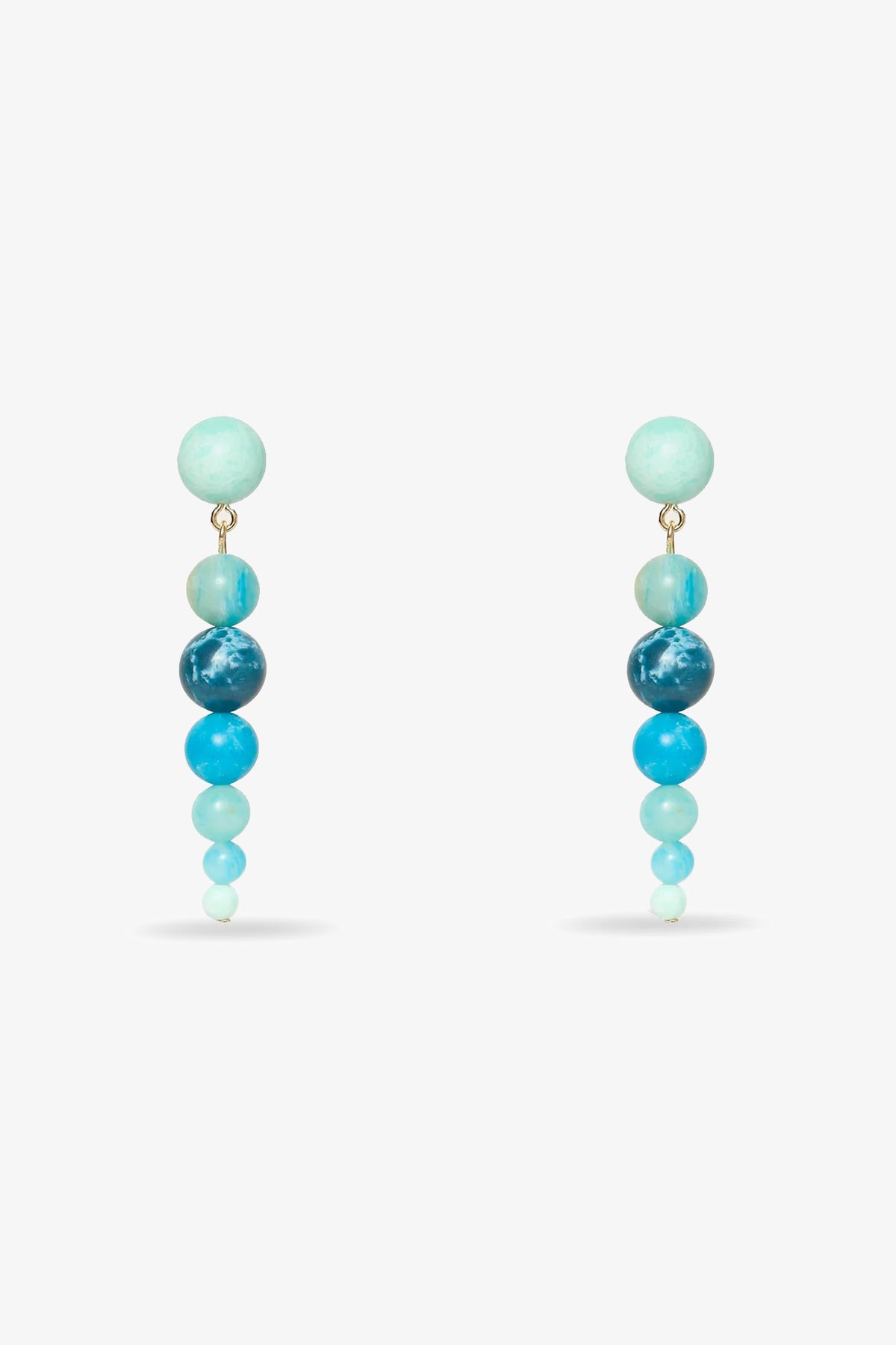 The Riviera Linear Drop Earrings feature five round beads each, arranged largest to smallest in gradient blue and turquoise hues, displayed on a white background.