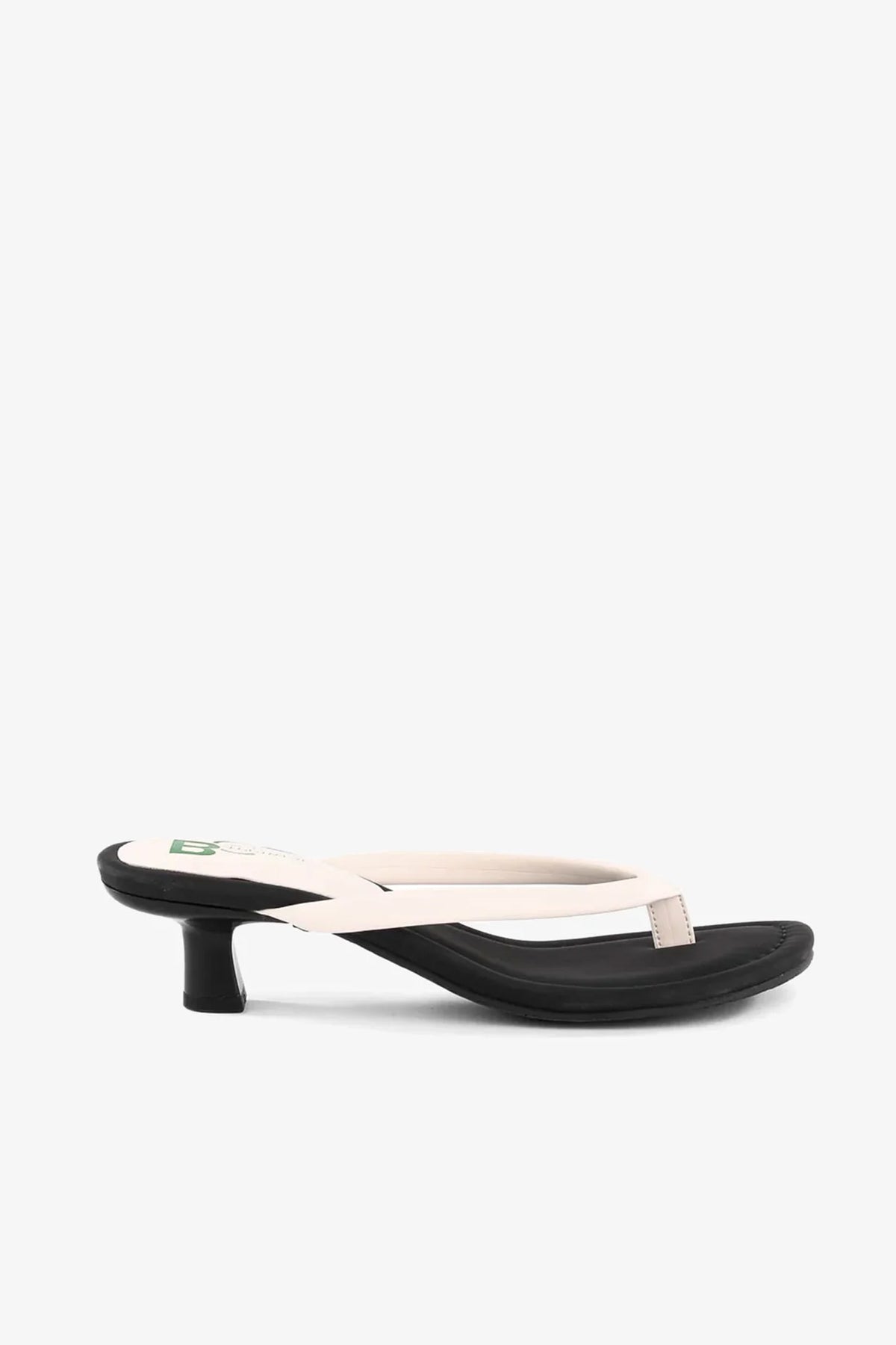A side view of the Riptide Sandal, featuring a black sole, low heel, and cream-colored thong straps, displayed on a plain white background.