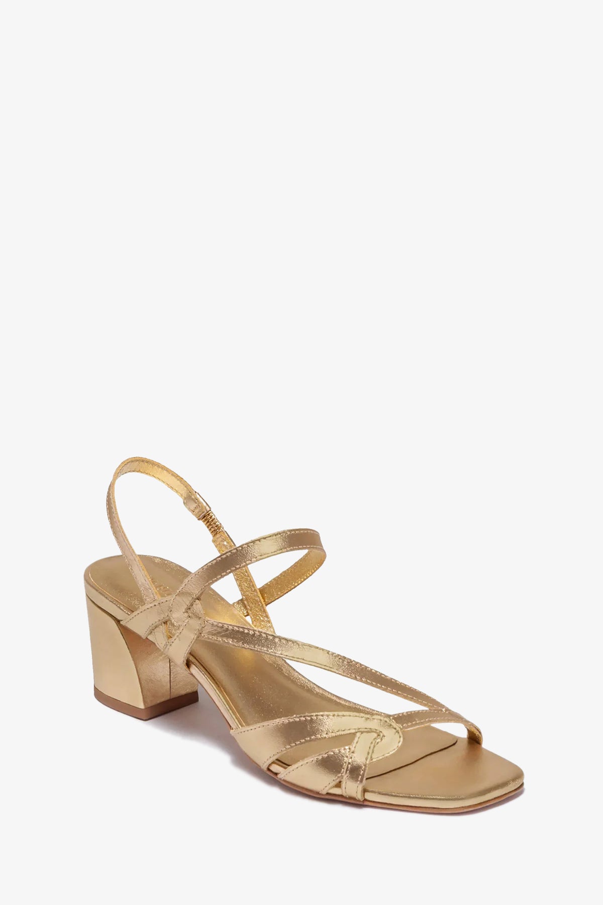 The Gyoda Heeled Sandal is a gold strappy sandal with a low block heel, open toe, thin crossed straps, and a slingback design, shown on a white background.