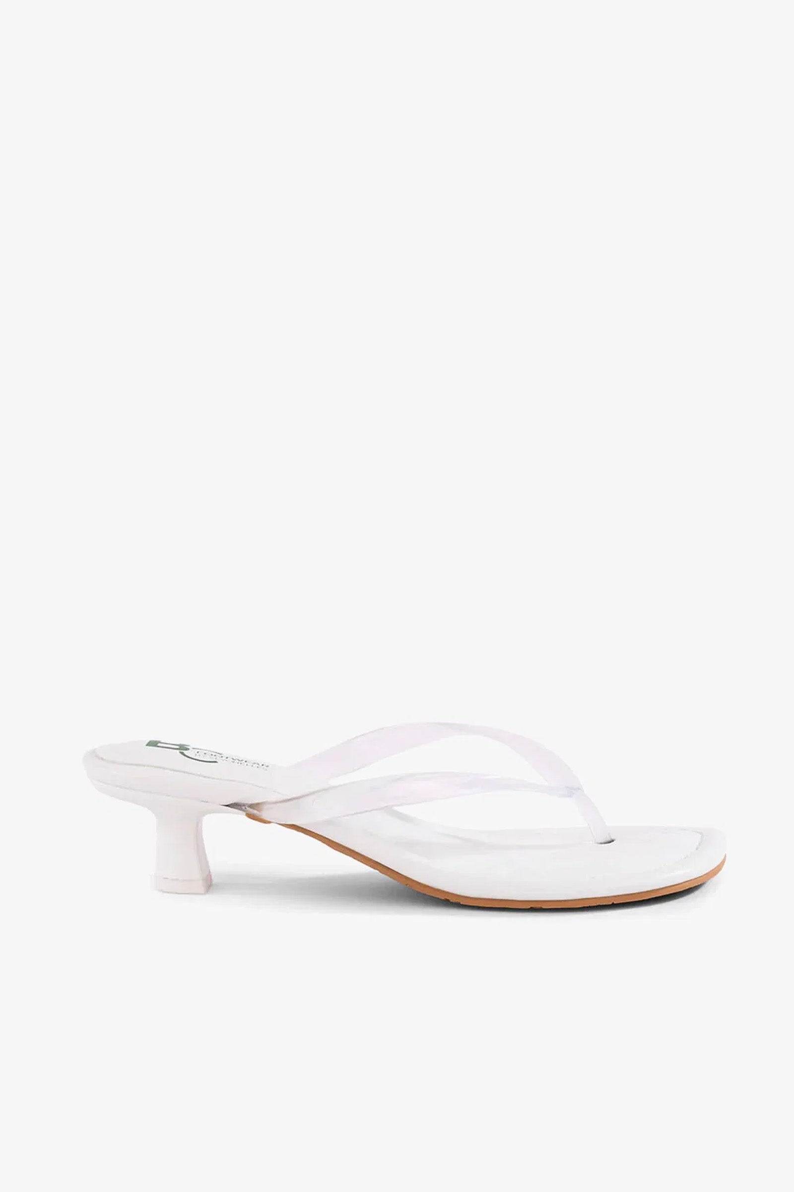 The Starbust Sandal, featuring a white thong strap design and a low, cylindrical heel, is displayed in a side view against a plain background.