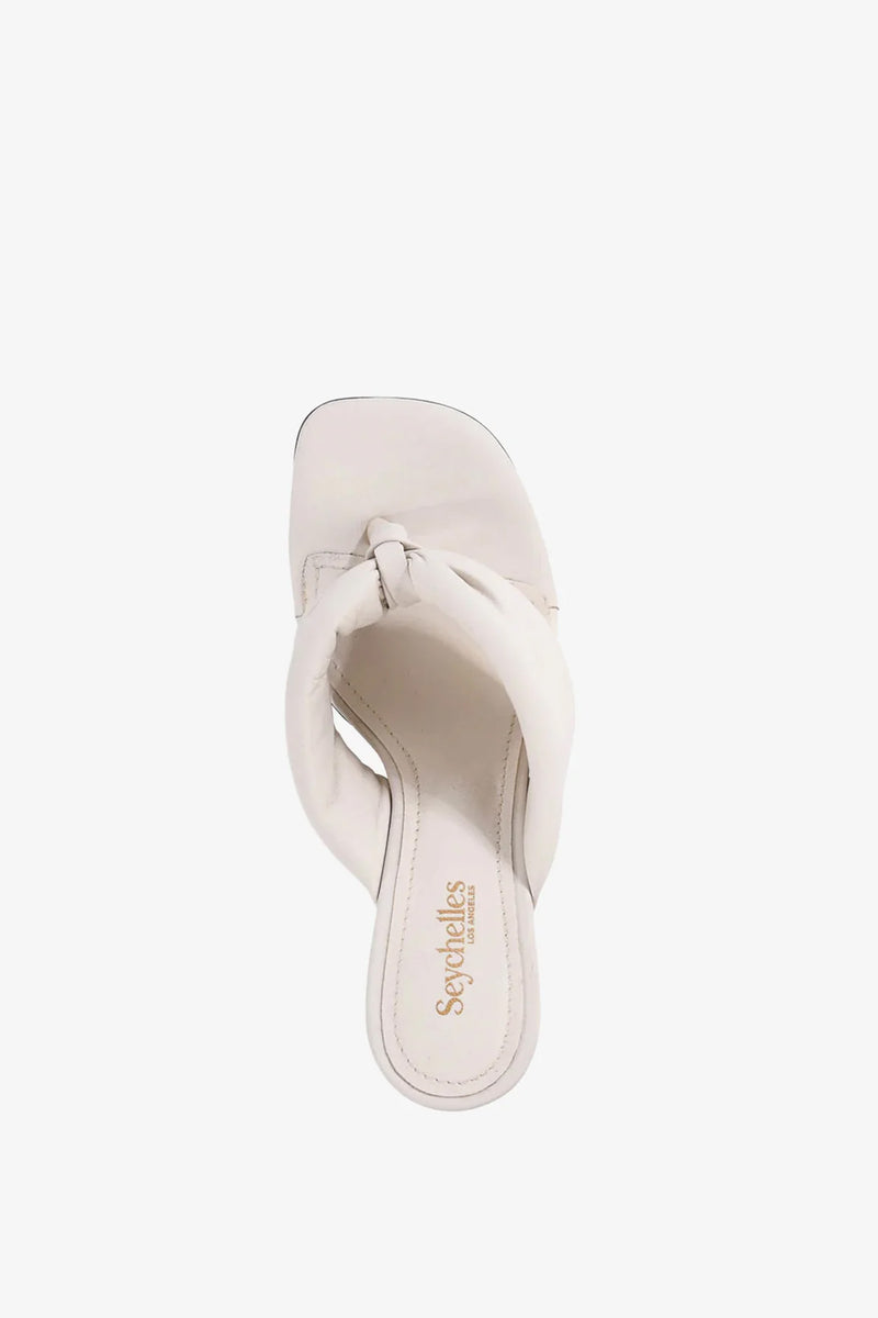 A single white Wishing Well Wedge sandal featuring a twisted strap design and a square toe, viewed from above. The insole displays Seychelles branding in gold lettering.