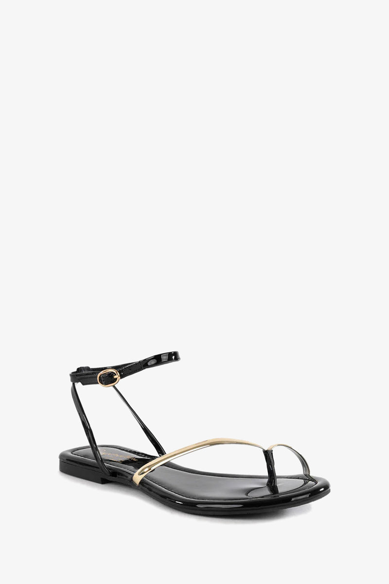 The A Little Extra Sandal is a black patent flat with gold toe and ankle straps.