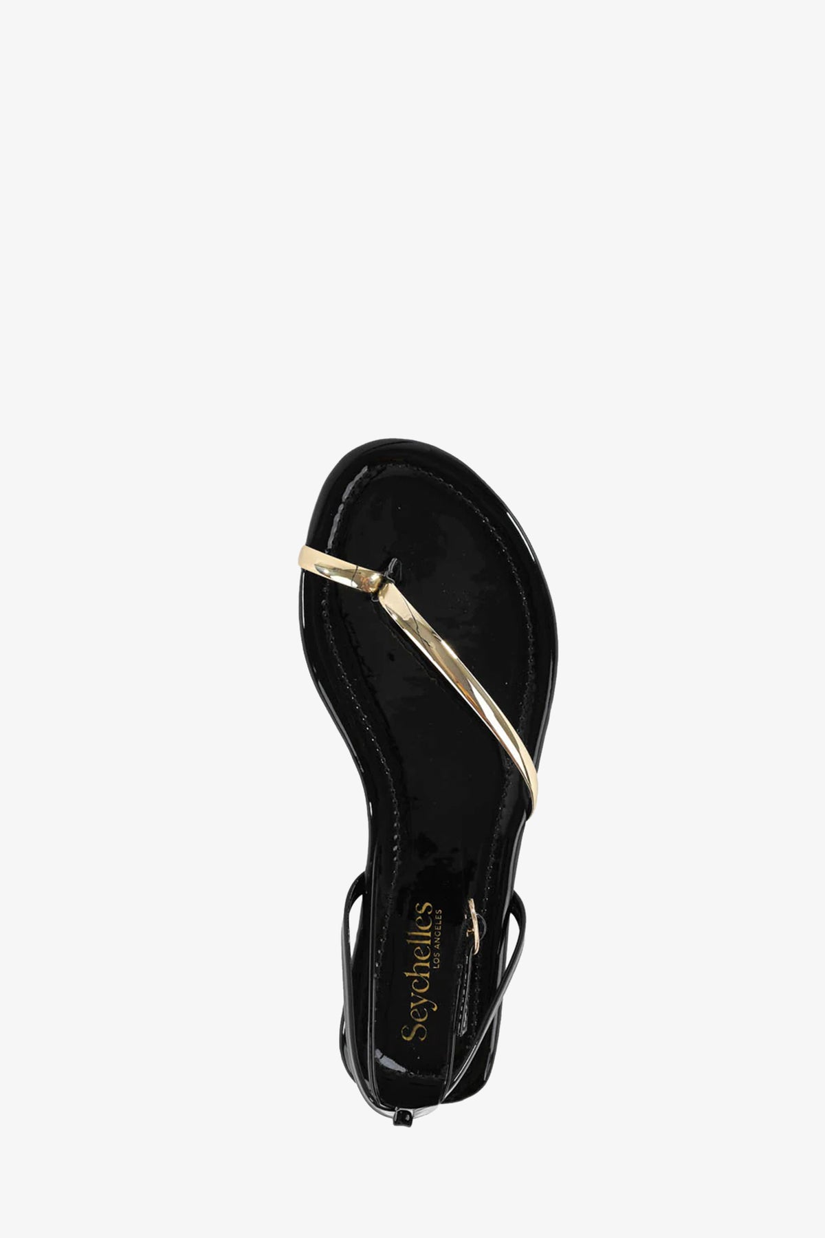 The A Little Extra Sandal is a black sandal with a shiny gold crisscross strap over the toe area, seen from above, and features the Seychelles brand name printed on the insole.