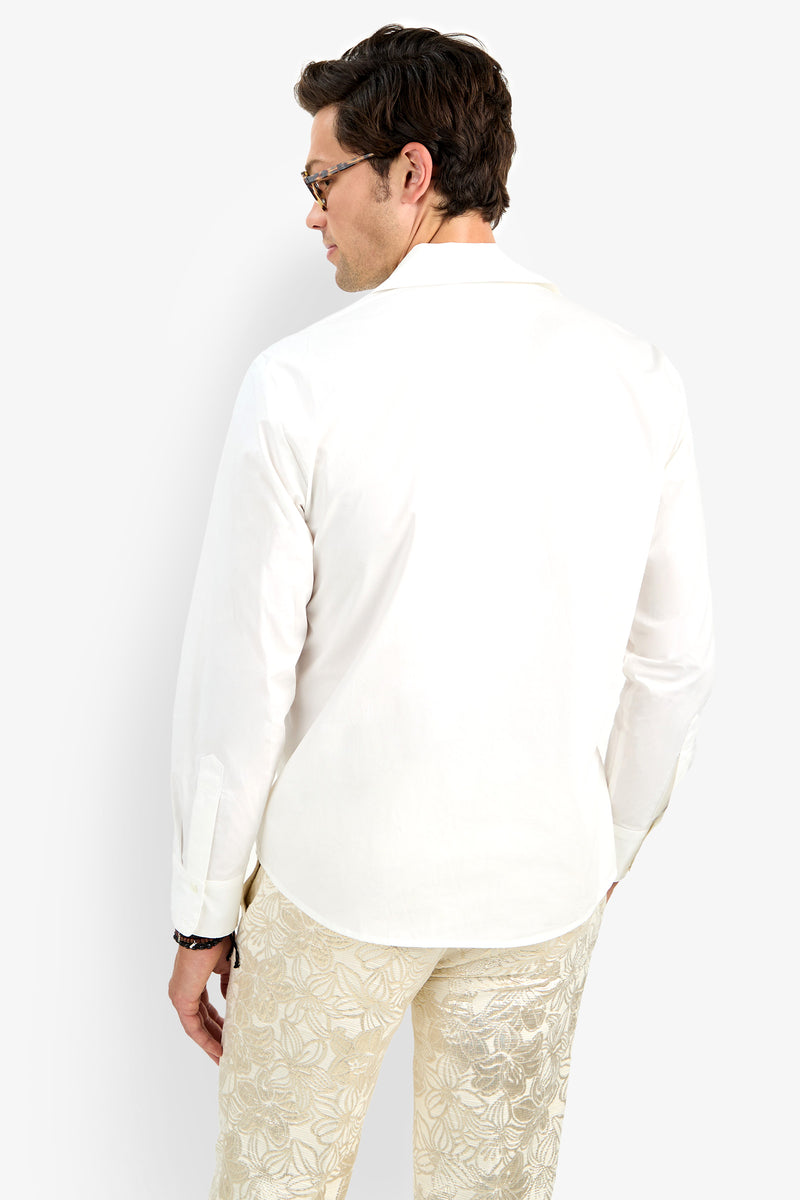 A man with short dark hair and glasses is shown from the back, wearing the Able Shirt—a white long-sleeve button-down—paired with light floral pants, standing against a plain white background.