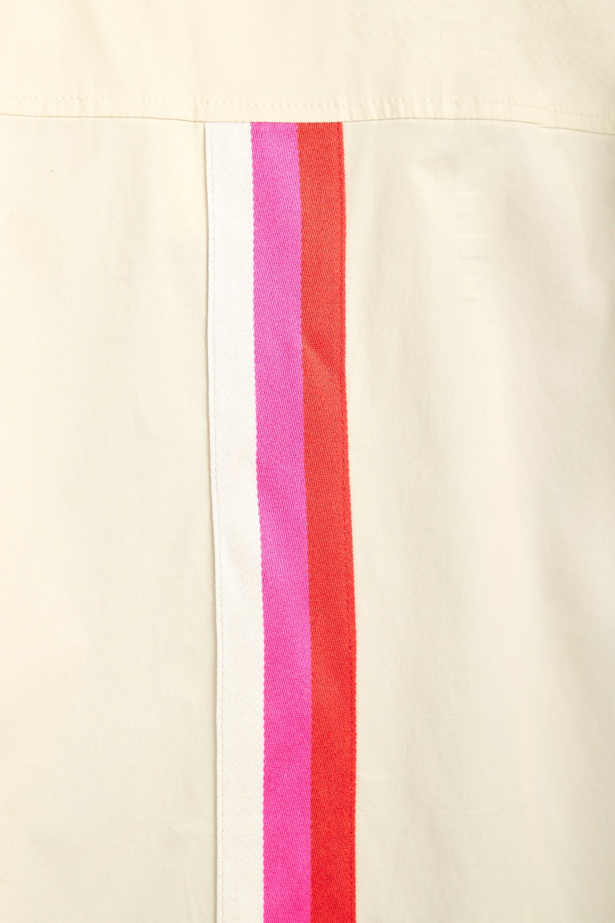 The OPPONENT DRESS features a cream-colored fabric with three closely spaced vertical stripes—white, pink, and red—running parallel along the seam.