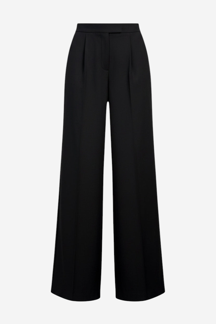 The Mimmo Pant is a pair of black, high-waisted, wide-leg dress pants featuring front pleats, belt loops, and a concealed closure, shown against a plain white background.