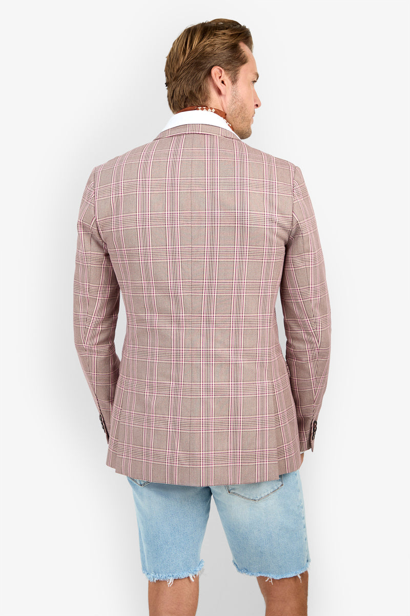 A man faces away wearing the THURSTON BLAZER in pink plaid over a white shirt and light blue frayed denim shorts, set against a plain white background.