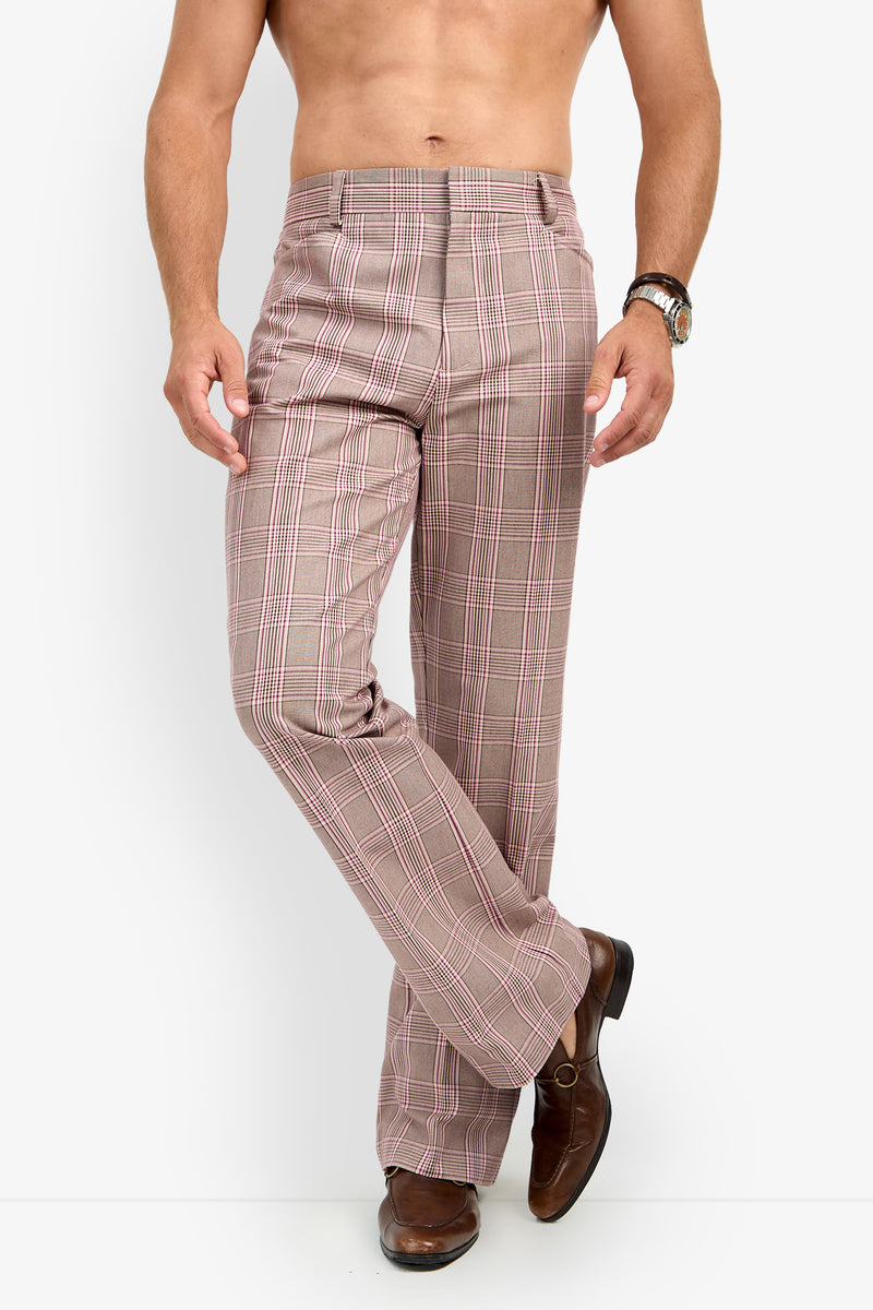 A shirtless man stands against a white background, wearing ALEJANDRO BOOTLEG TROUSER brown plaid dress pants and brown dress shoes, with one leg crossed in front of the other and a hand on his hip.