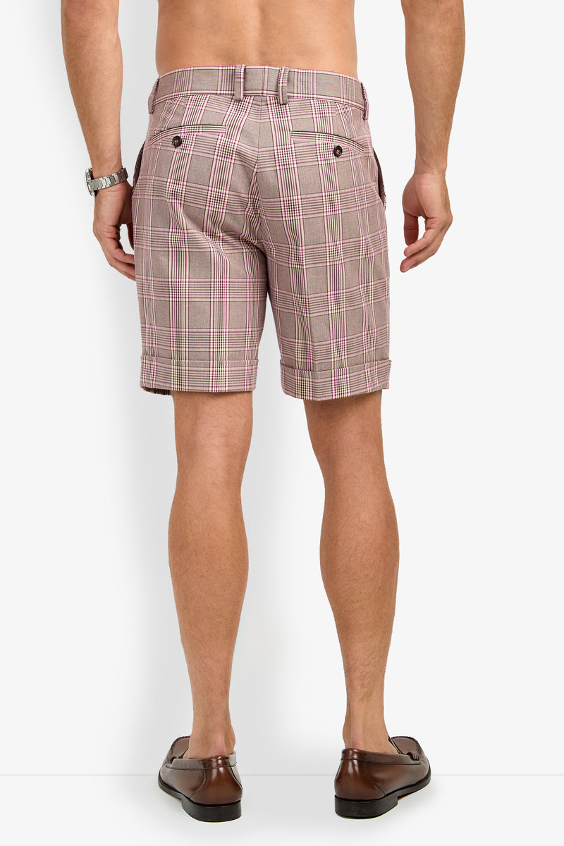 A man is shown from the back, shirtless, wearing OLIVER PLEATED SHORT plaid shorts in red and white, brown loafers, and a wristwatch, standing against a white background.