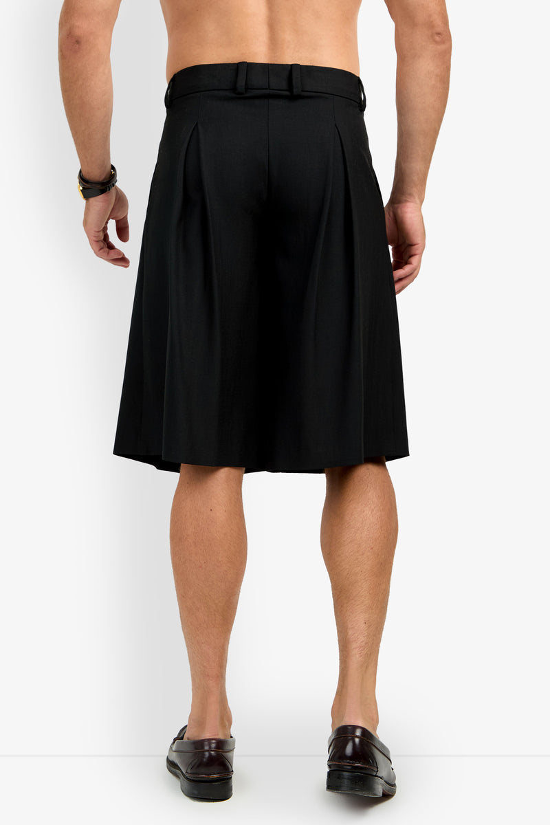 A shirtless man is shown from the back, wearing black GALFANO WIDE LEG SHORTS, a black belt, brown bracelet, and brown loafers, standing against a plain white background.