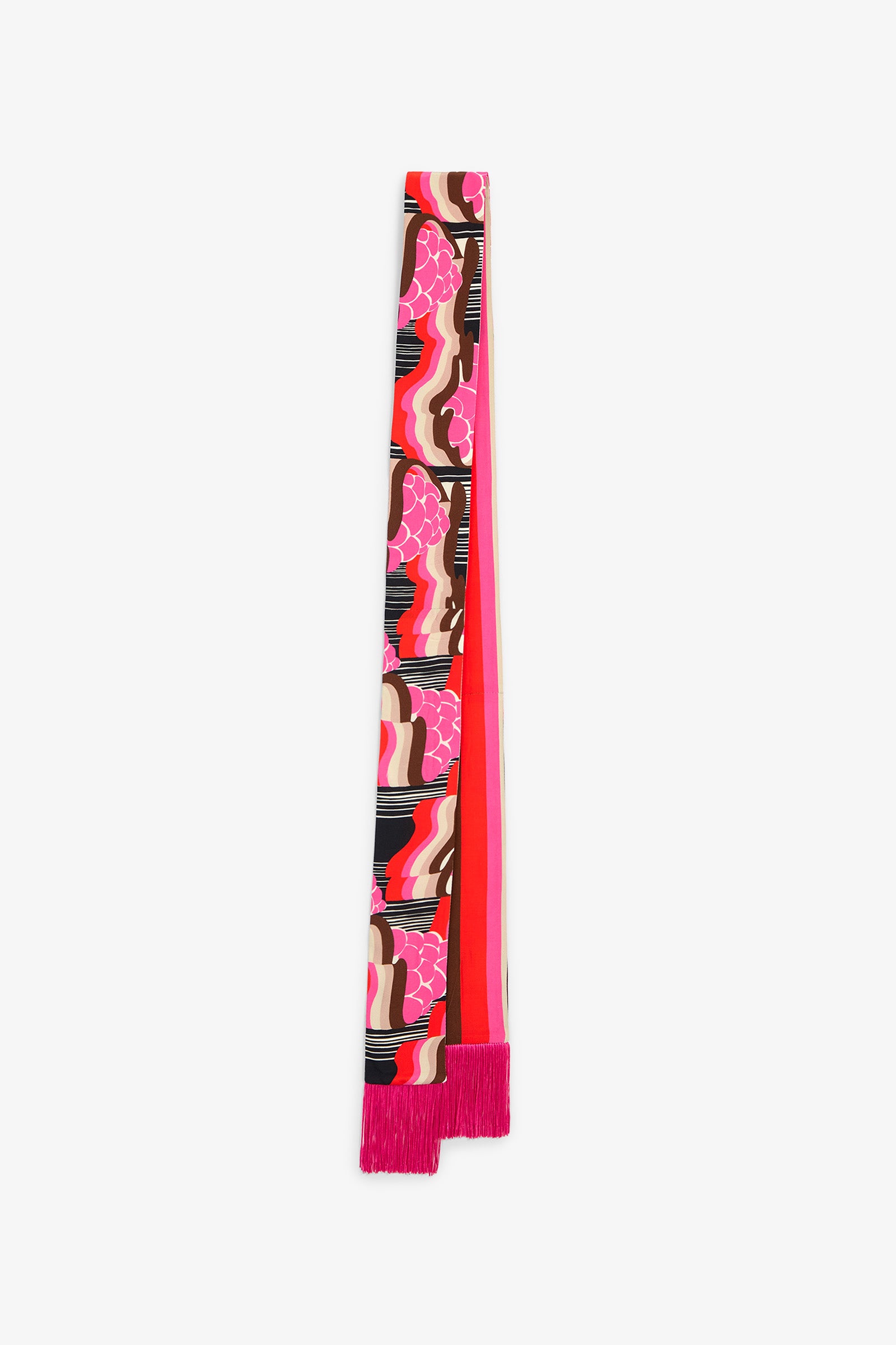 Introducing the Giostra Fringe Scarf: a long, narrow accessory adorned with abstract pink, red, black, and white patterns. One end features fringed pink tassels while the opposite end is finished with a deep red strip. The scarf is displayed flat on a white background.