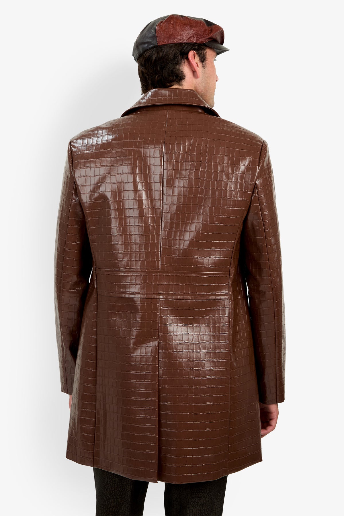 A person wearing the Morton Trench Coat, featuring a shiny brown crocodile-pattern texture, along with a matching brown cap, shown from the back against a plain white background.