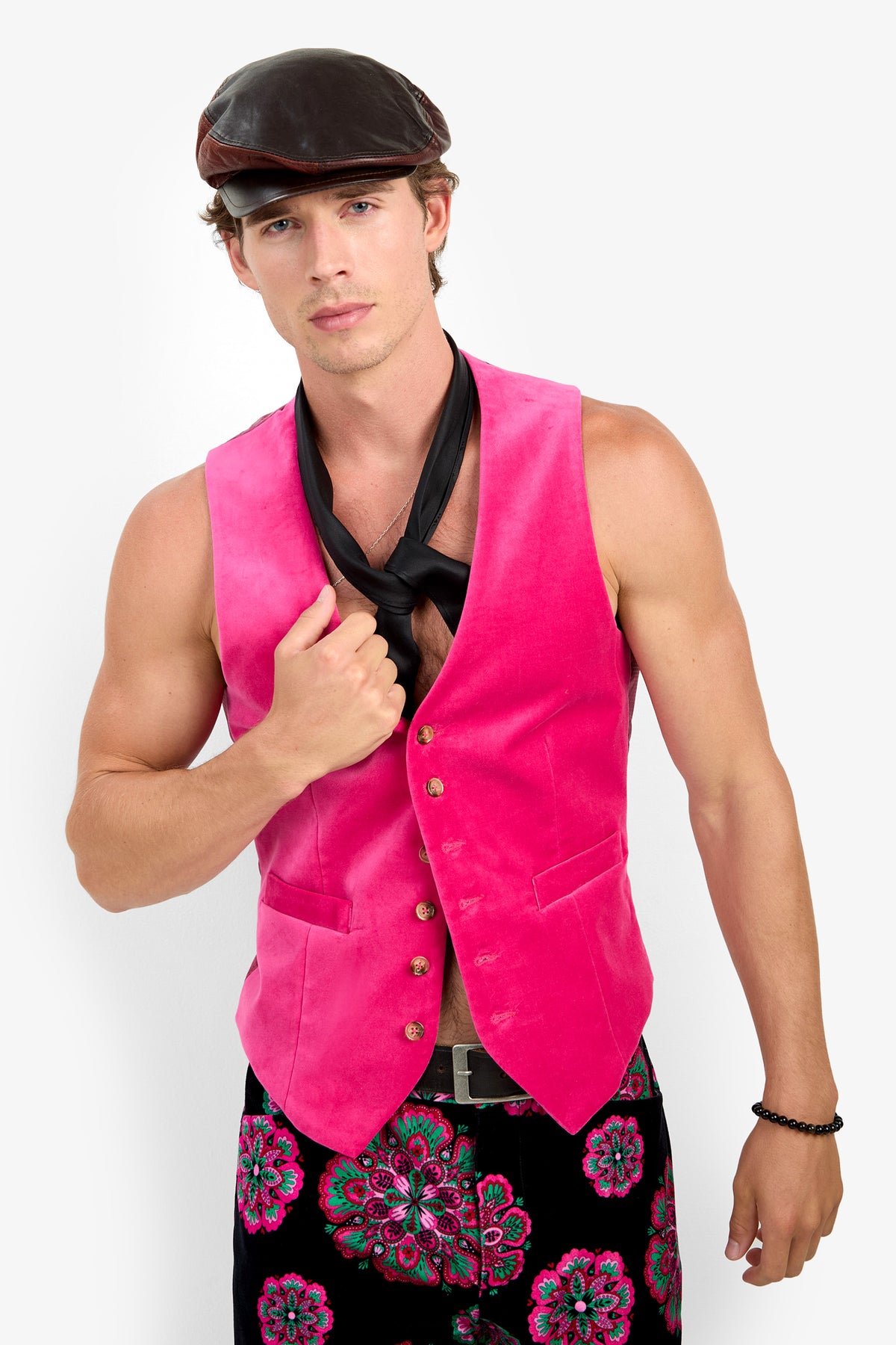 A man wearing the Irving Vest paired with a black necktie, newsboy cap, and floral-patterned pants stands against a plain background, looking at the camera with a neutral expression.