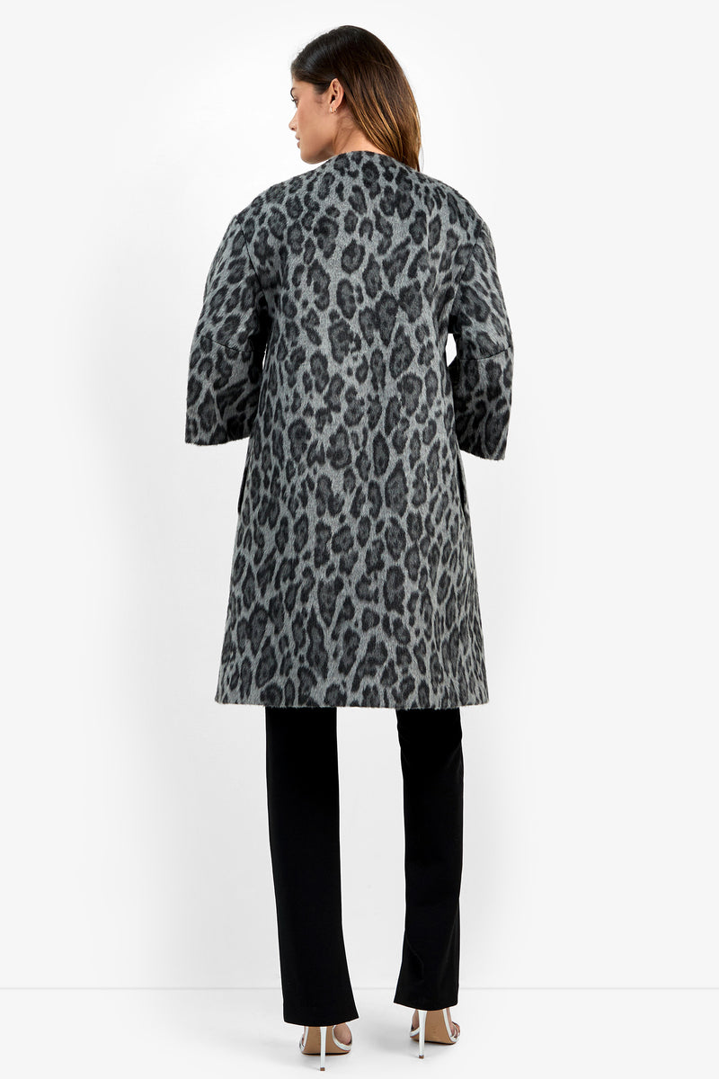 A woman stands with her back to the camera, wearing the Lovely Leopard Coat in gray, paired with black pants and high-heeled shoes against a plain white background.