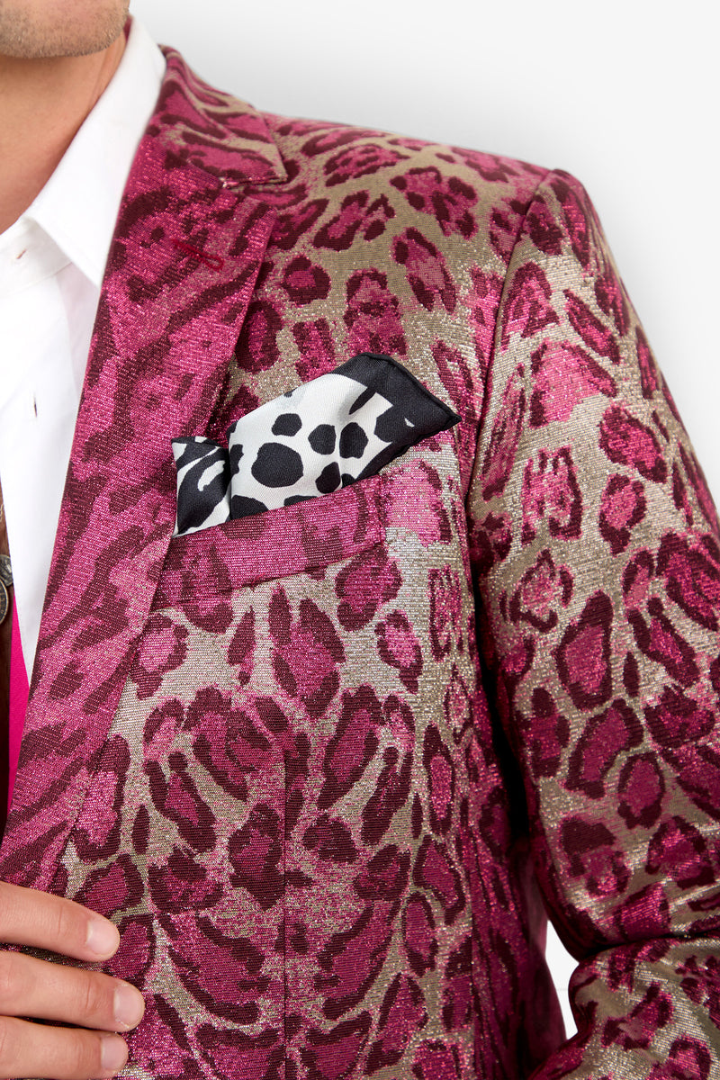 A person wearing the Thurston Blazer—a metallic pink and gold leopard print jacket—paired with a white shirt and a black-and-white animal print pocket square. Only the upper torso is visible.