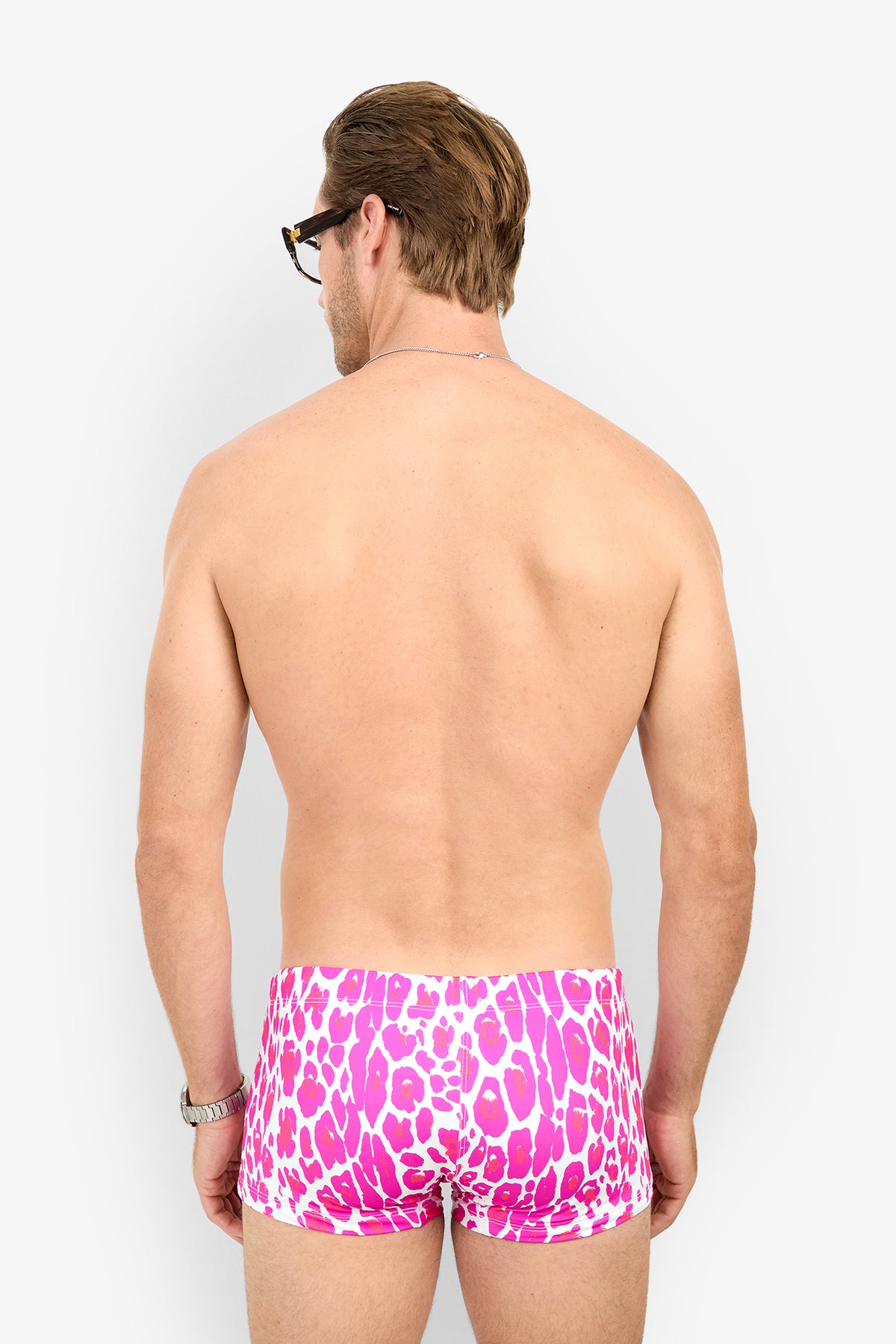 A man seen from behind wearing pink and white leopard-print MONTEGO BAY SWIM TRUNK.
