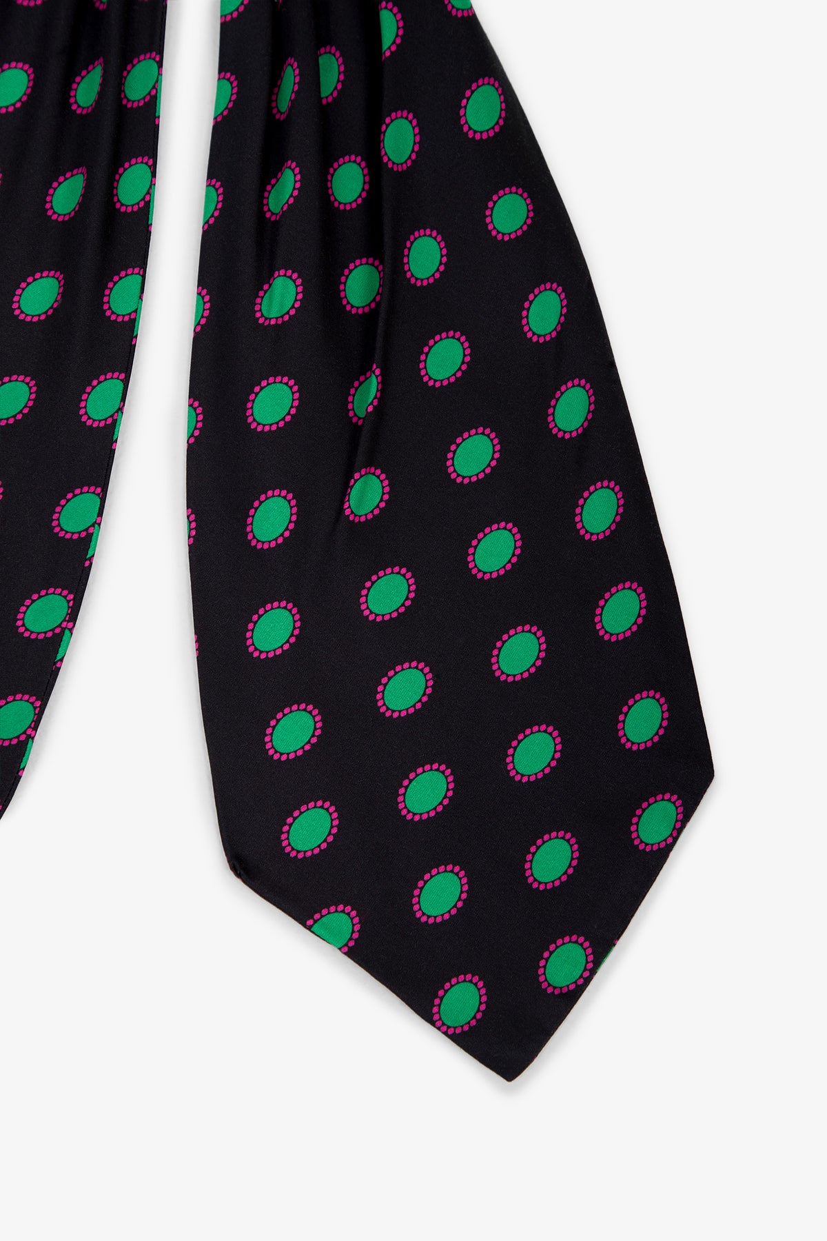 A close-up of the Gemstone Satin Ascot showcases its smooth black fabric, featuring a uniform pattern of green oval dots outlined in pink.