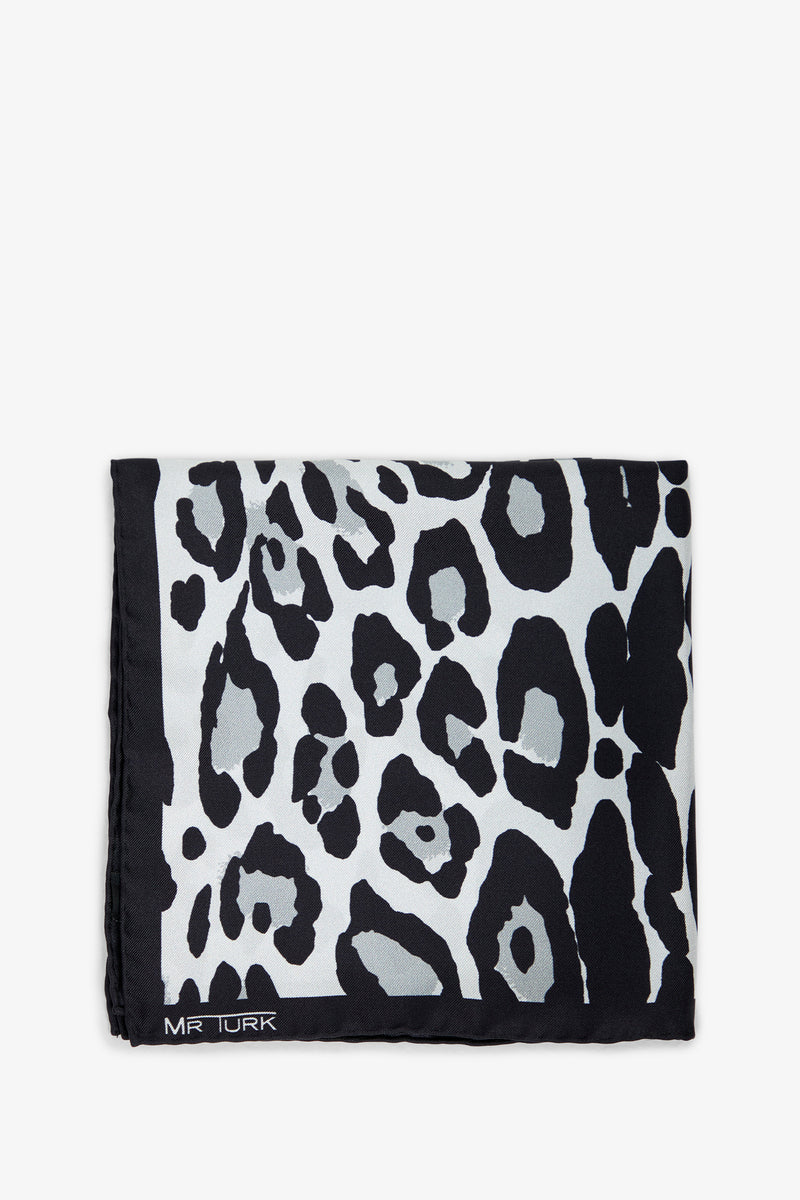 A folded Snow Leopard Pocket Square featuring a black and white leopard print and MR TURK in white text on one corner.