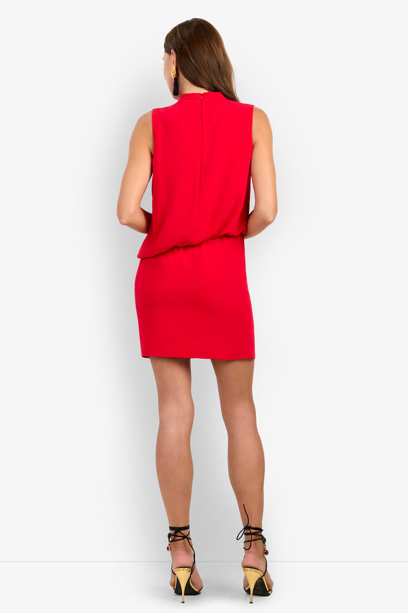 Back view of the red LENAYA DRESS, a sleeveless 100% polyester mini dress with a draped bodice, worn with black strappy heels.