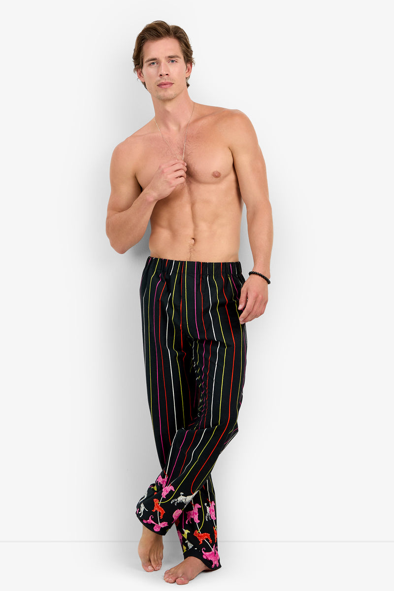Shirtless man wearing black PJ PANT 100% cotton pajama pants featuring vertical neon stripes and a colorful animal print pattern at the cuffs.