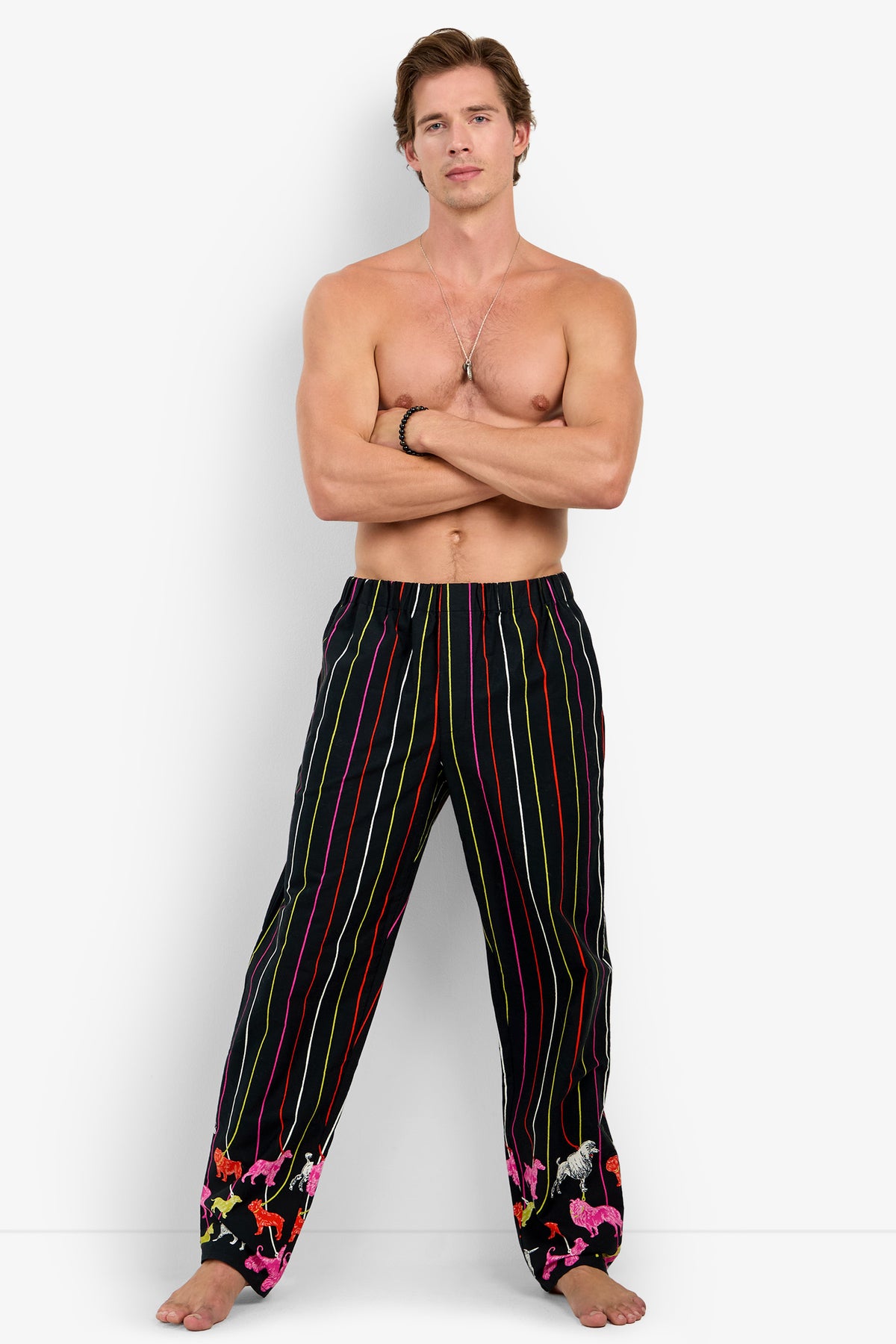 Shirtless man wearing PJ PANT in 100% cotton black with vertical multicolored stripes and small animal silhouettes at the hem.