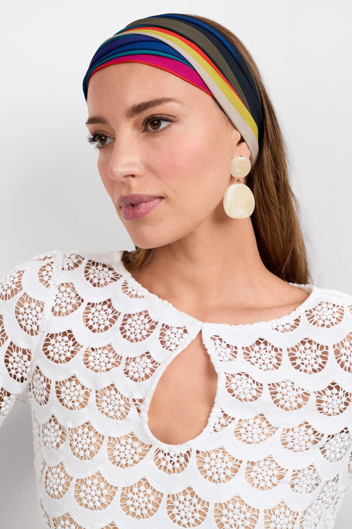 A woman wearing a colorful striped headband, large round earrings, and the Lita Crochet 3/4-Sleeve Dress with a scalloped lace keyhole neckline gazes slightly to the side against a plain background.