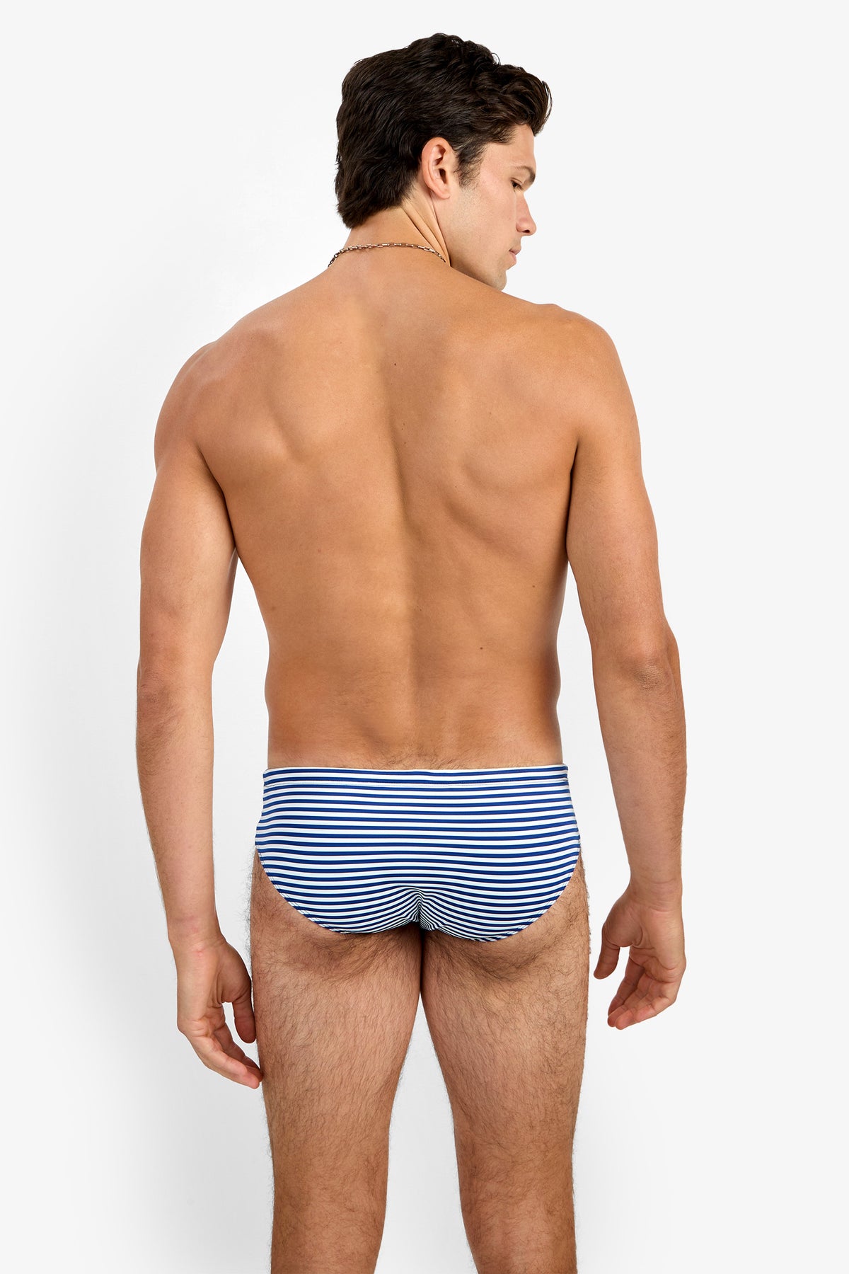 A man with short brown hair stands shirtless, facing away from the camera, wearing the Bondi Swim Brief against a plain white background.