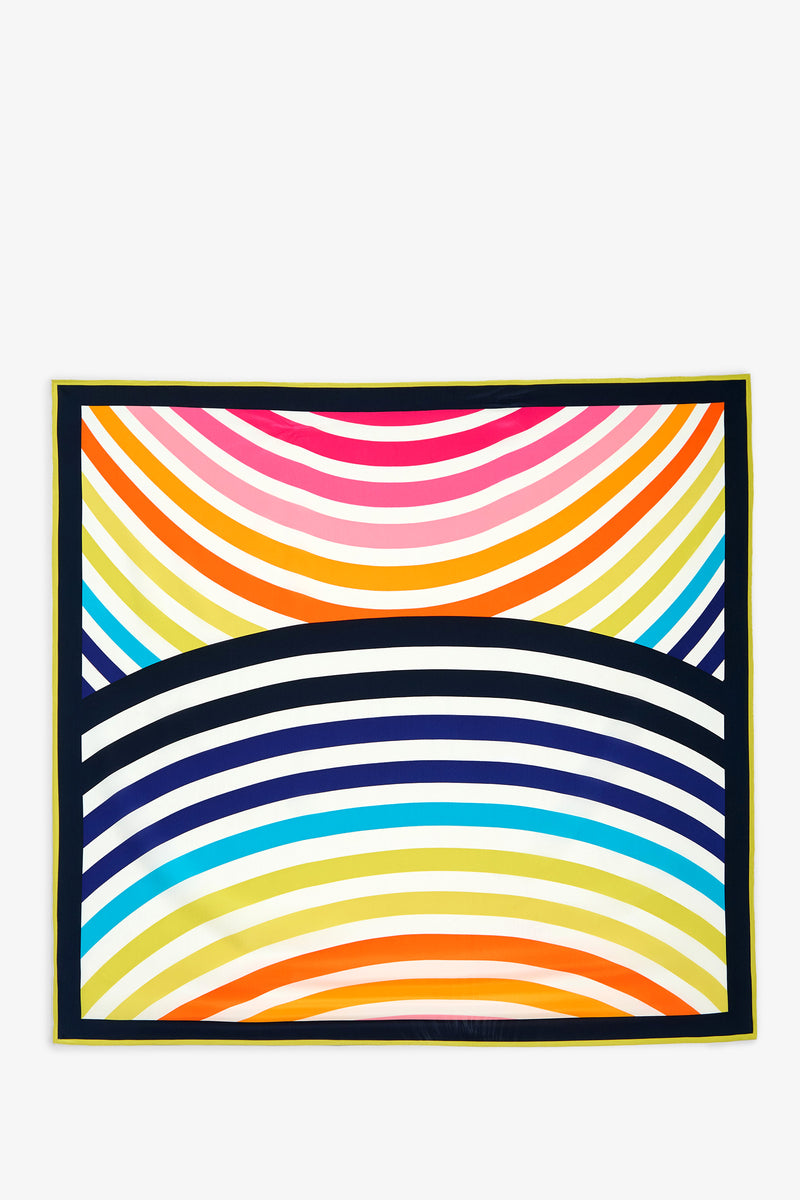 The Circle Scarf is a rectangular textile featuring curved stripes in vibrant colors—pink, orange, yellow, blue, and black—arranged in symmetrical, rainbow-like arcs with a black border.