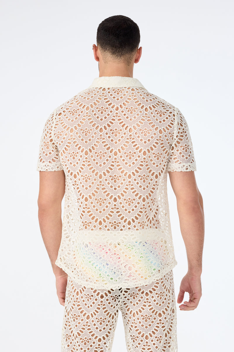 A man stands with his back to the camera in a matching cream Long Beach Short-Sleeve Shirt and pants set, both featuring intricate crochet lace openwork patterns, against a plain white background.