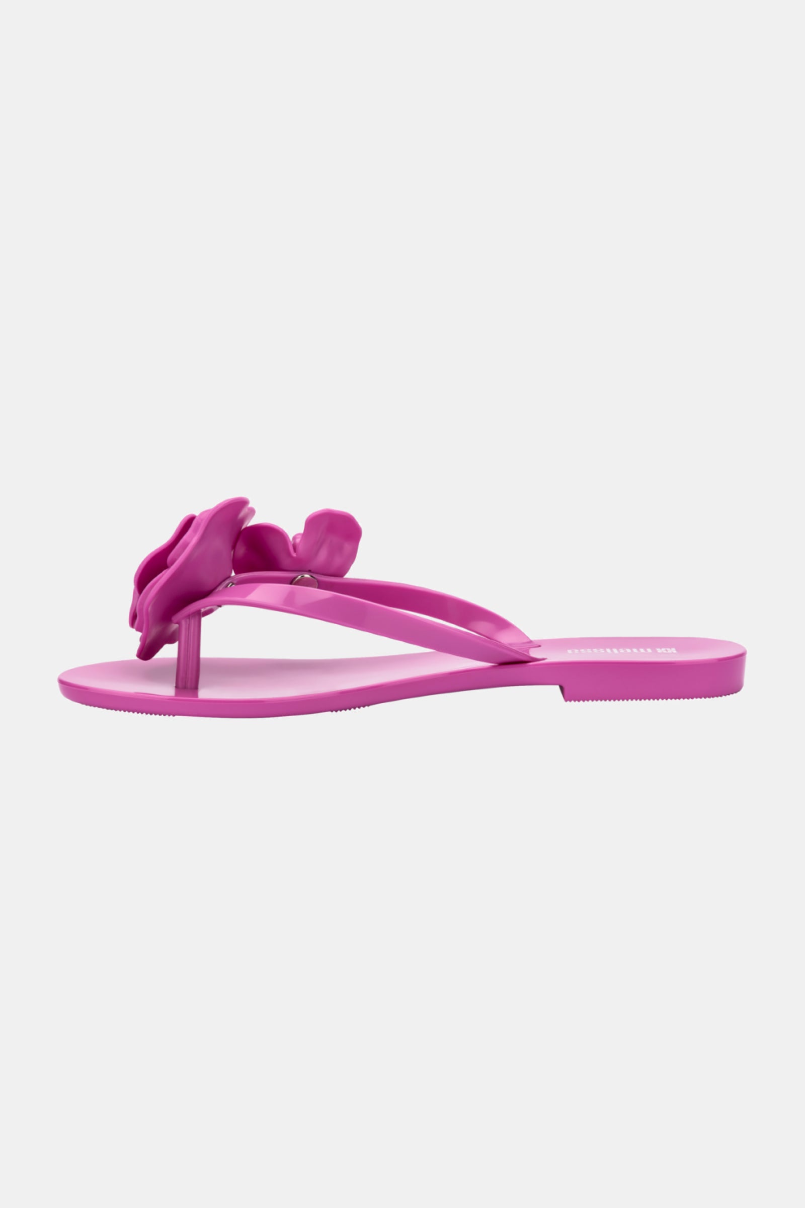 The Melissa Harmonic Petals Sandal is a bright pink flat thong sandal featuring a decorative flower on the strap, displayed in a side profile against a plain white background.