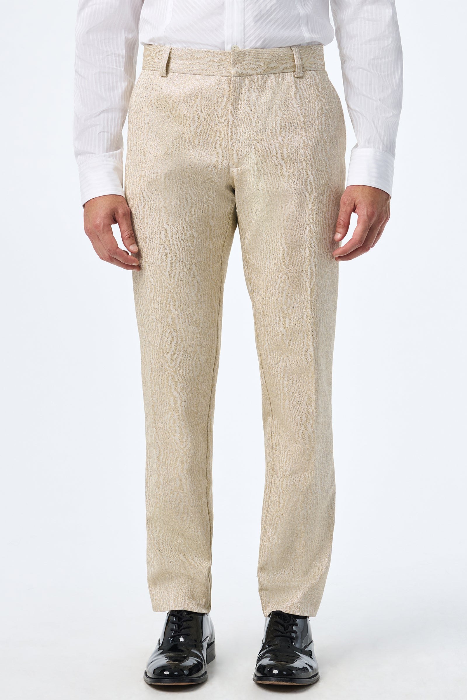 A person wearing Clyde Slim Trouser in light beige, a white dress shirt, and black shiny dress shoes stands against a plain white background.