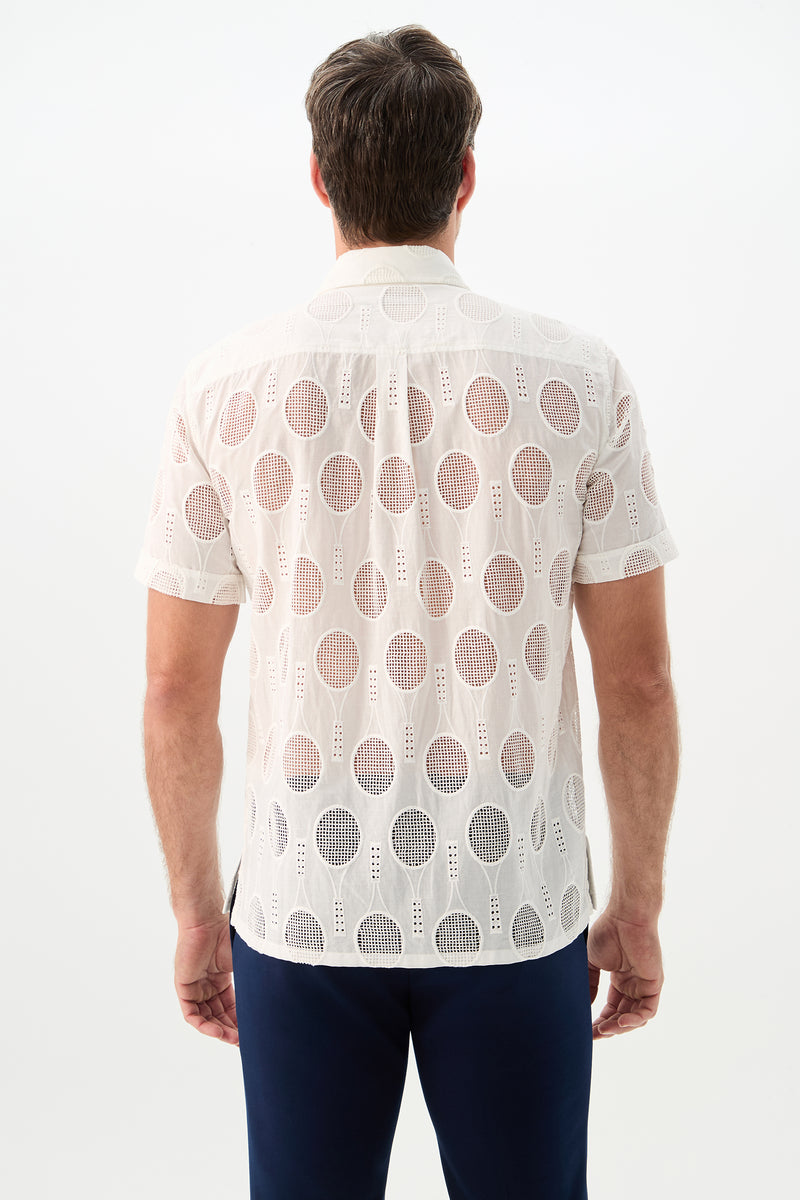 A man is shown from the back wearing the Branson Shirt - Tennis Eyelet, a short-sleeve, white, semi-sheer shirt with a circular geometric pattern, paired with dark pants against a plain white background.