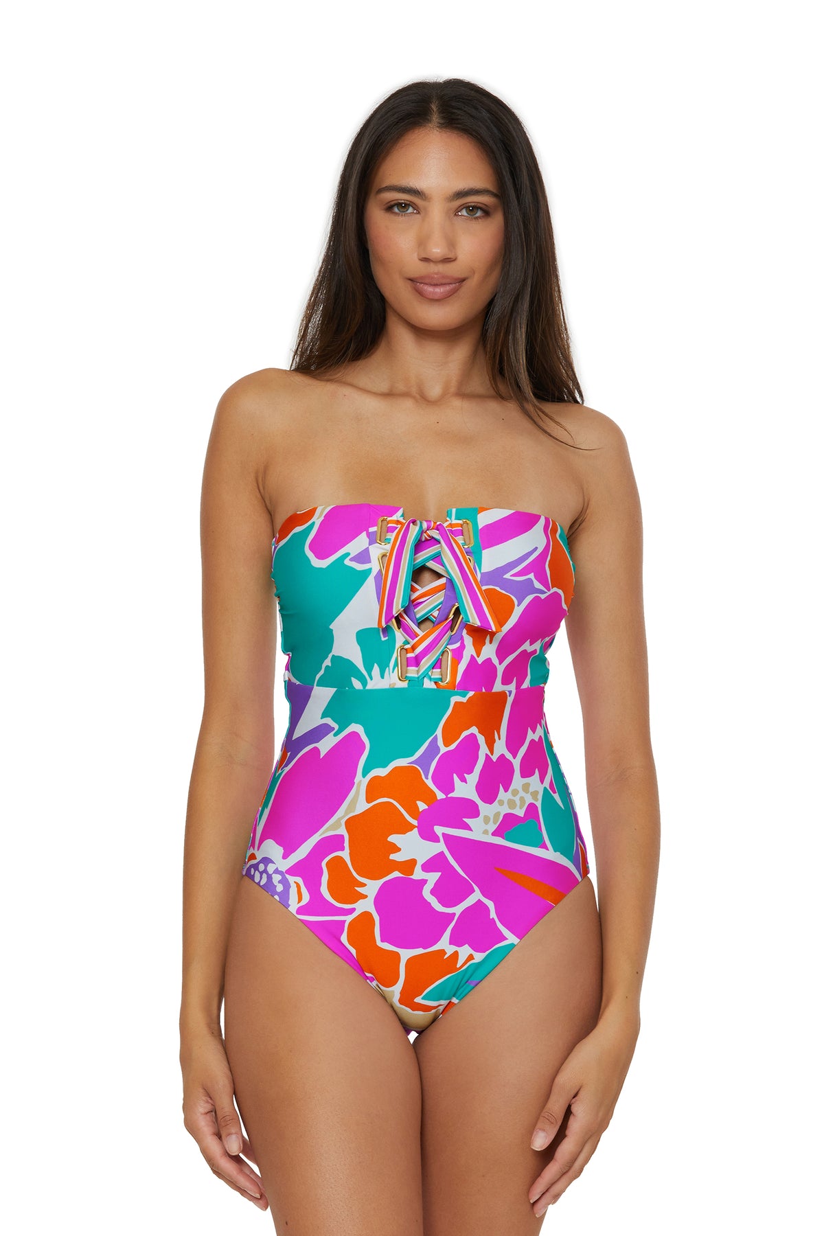 A woman models the Lace-Up Bandeau One-Piece Swimsuit in Amalfi, featuring a vibrant strapless design with a bold floral print and lace-up front, standing facing forward against a white background.