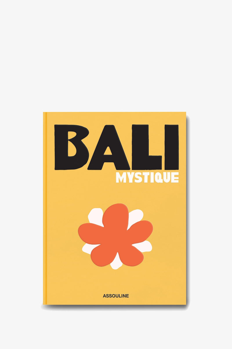 ASSOULINE BALI MYSTIQUE features a yellow book cover with bold black text that reads “BALI” and smaller white text “MYSTIQUE” above a red and white abstract flower design. The publisher name, ASSOULINE, appears at the bottom.