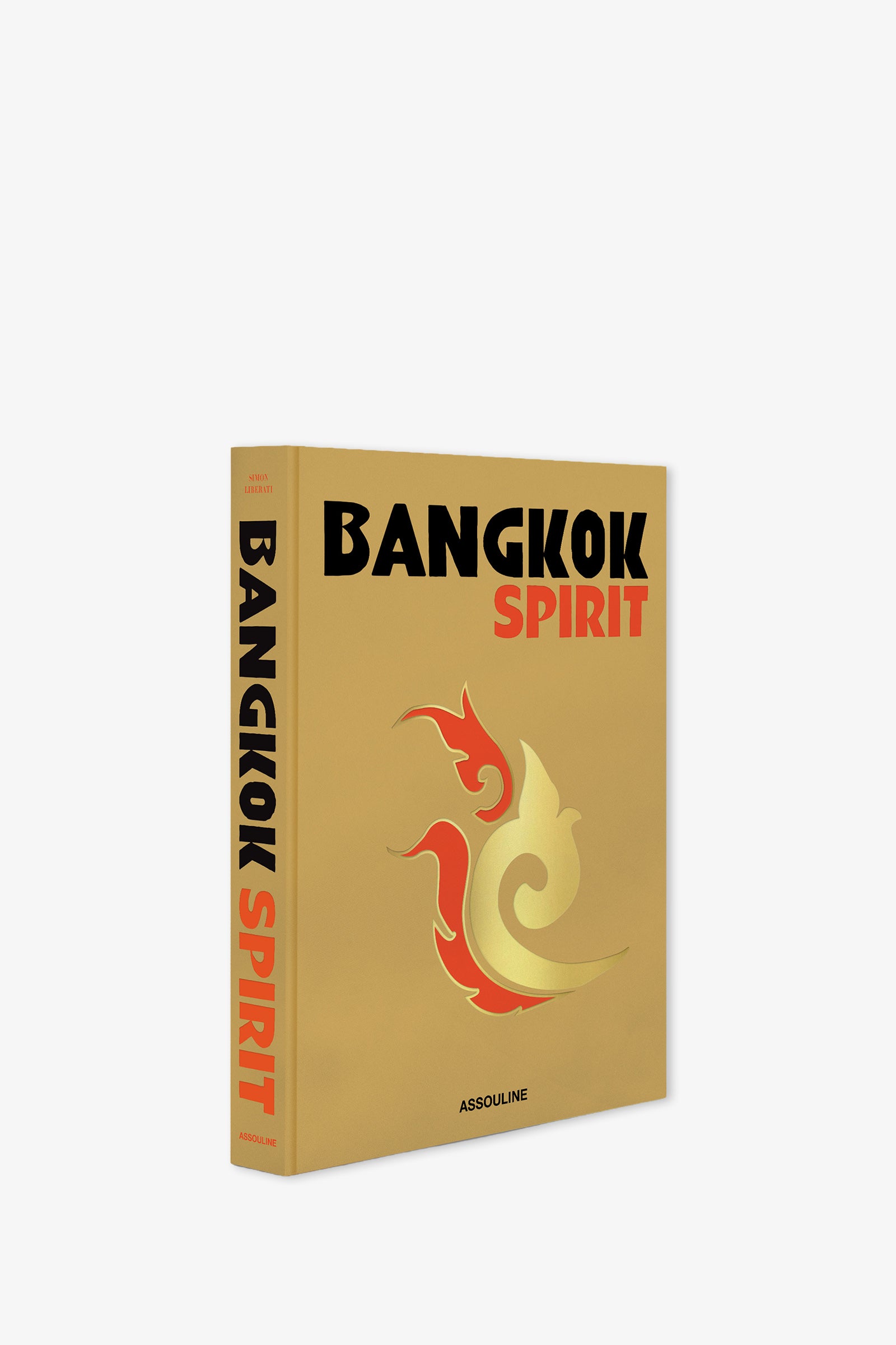 The Assouline Bangkok Spirit Book features a gold cover adorned with bold black and red lettering and a striking red and gold stylized phoenix design. The spine is visible, along with the publisher's name, Assouline.