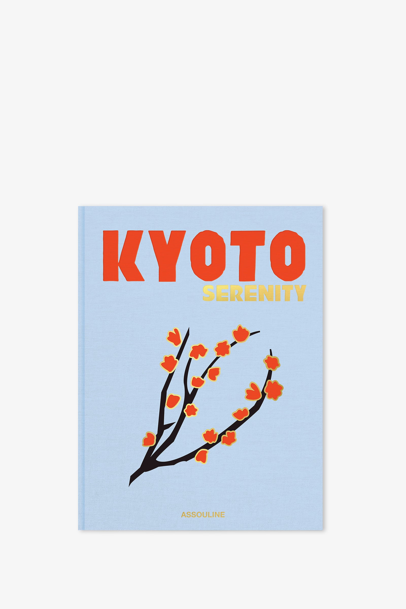 A light blue Assouline Kyoto Serenity Book featuring bold orange and yellow lettering on the cover, adorned with an illustration of a branch with red-orange flowers. The publisher "Assouline" appears at the bottom.