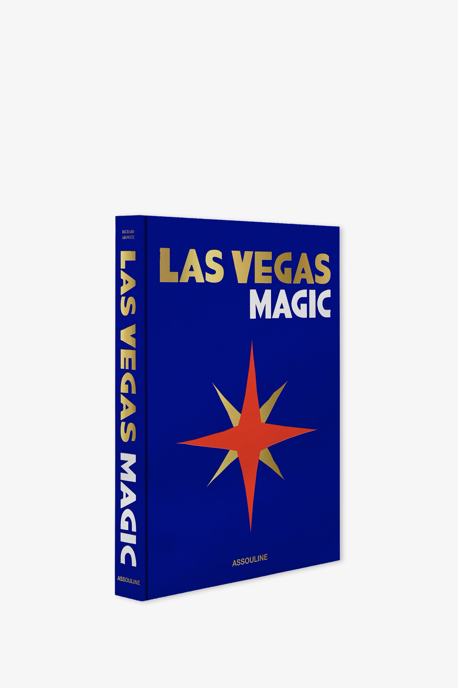 A blue Assouline Las Vegas Magic Book featuring gold and white text and a red and orange starburst design on the cover; the spine also reads "LAS VEGAS MAGIC.