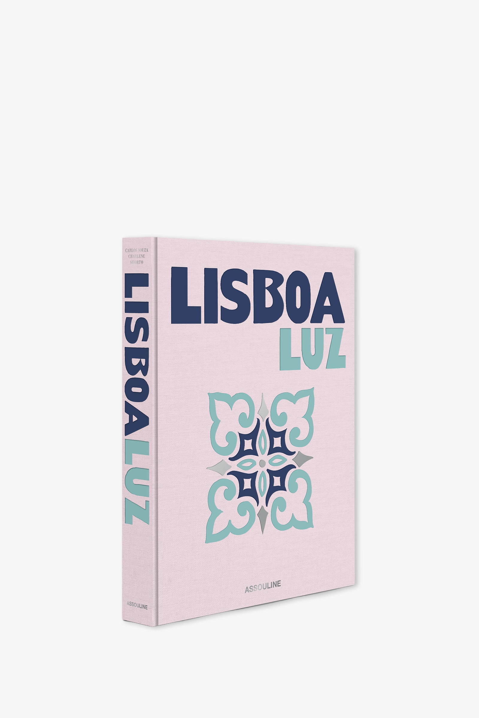 The Assouline Lisboa Luz Book is a pink hardcover featuring bold blue and teal text and a decorative floral tile pattern on the front, with the title displayed vertically on the spine.