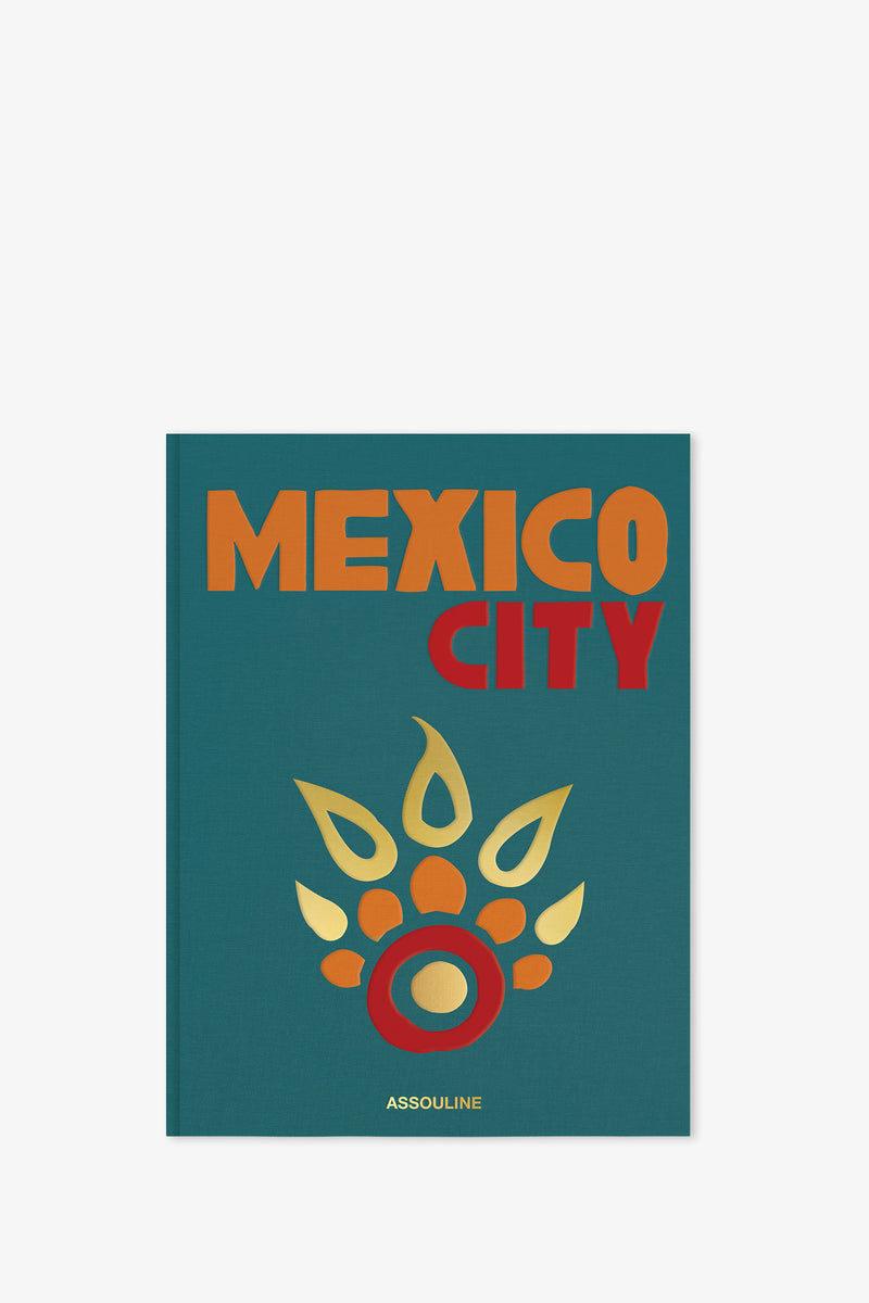 The Assouline Mexico City Book features bold orange and red lettering on a teal cover with a stylized, golden Aztec-inspired design, and the publisher’s name, Assouline, at the bottom.