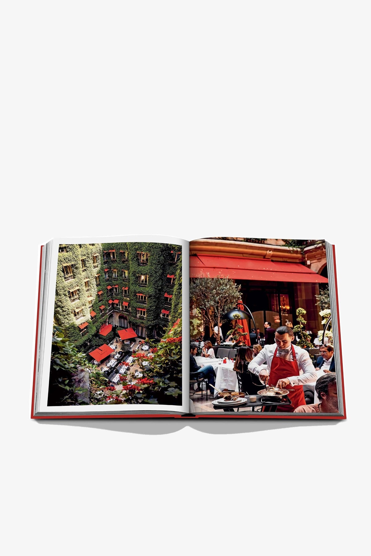 An open Assouline Plaza Athénée book displays the hotel’s ivy-covered courtyard with red awnings on the left page and a waiter in a red apron serving guests at an outdoor café on the right.