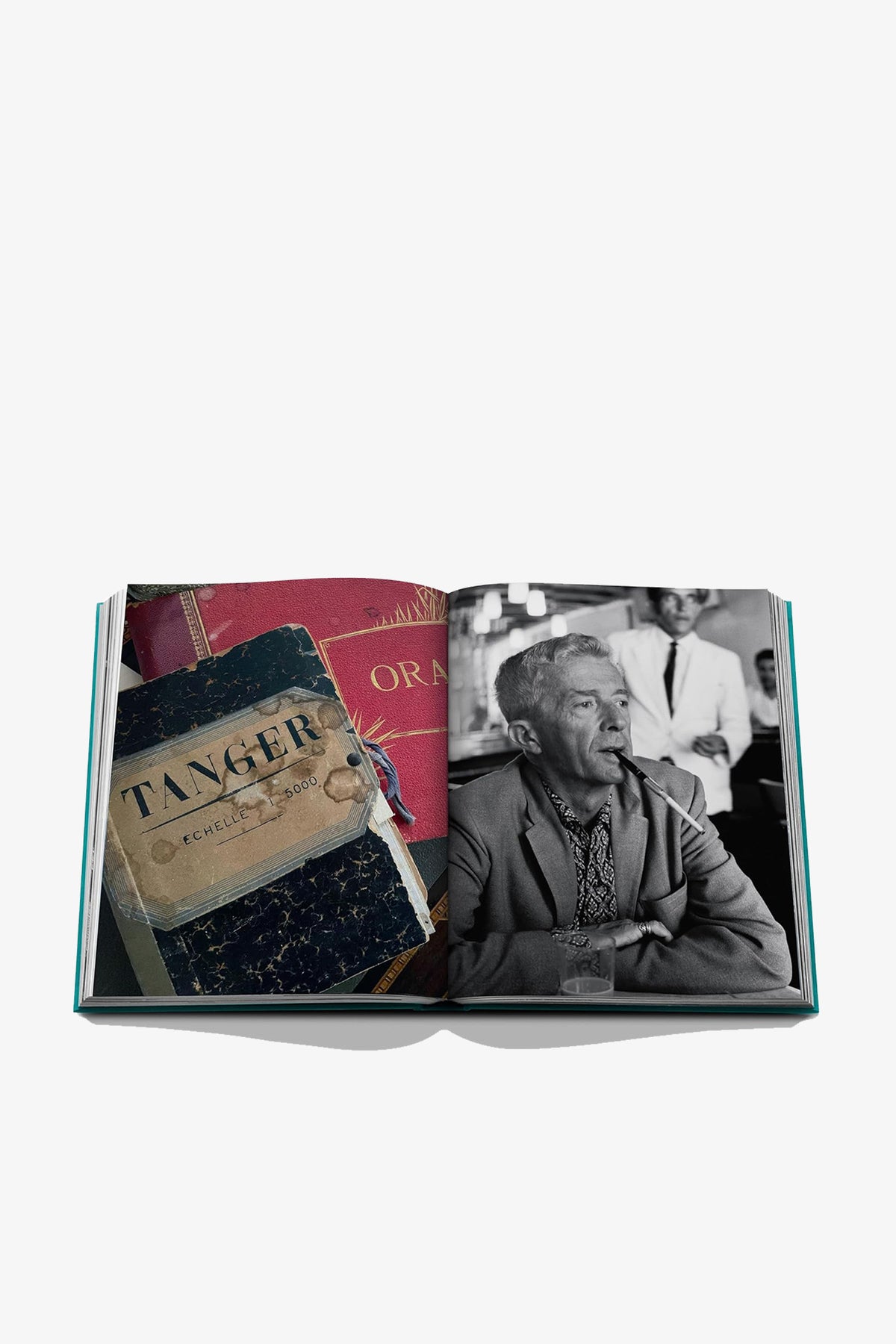 Open book from the Assouline Tangier Tangerine collection, showing a vintage map labeled Tanger on the left page and a black-and-white photograph of a man smoking a cigarette on the right page.