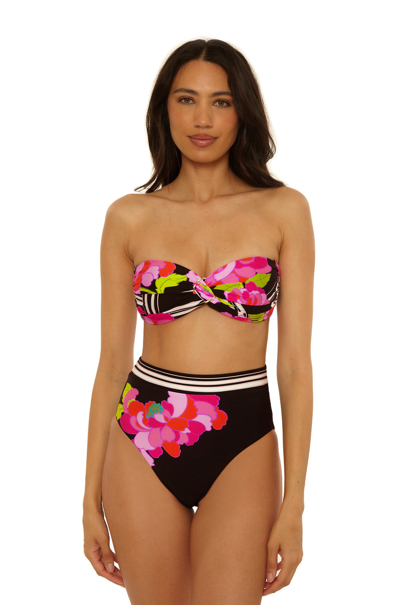 A woman wears the Twist Bandeau Swim Top in Bougainvillea Swim Knit with high-waisted bottoms, standing facing forward against a white backdrop.
